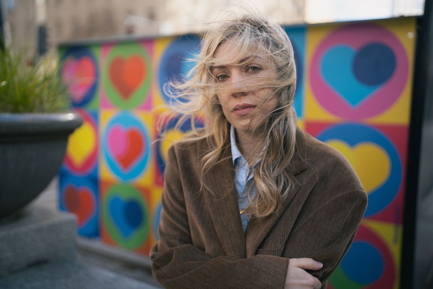Portrait session against a colorful street art mural with vibrant hearts and circles.