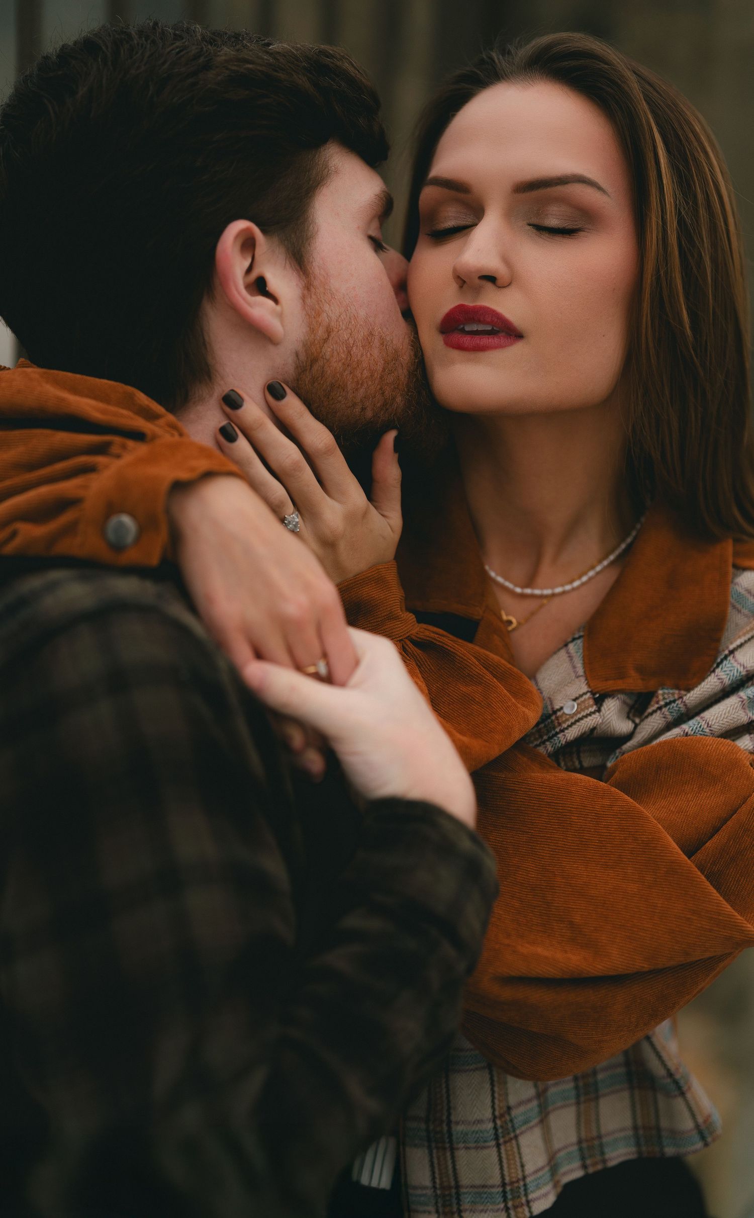 Romantic close-up photos of a couple in autumn clothing sharing intimate moments.