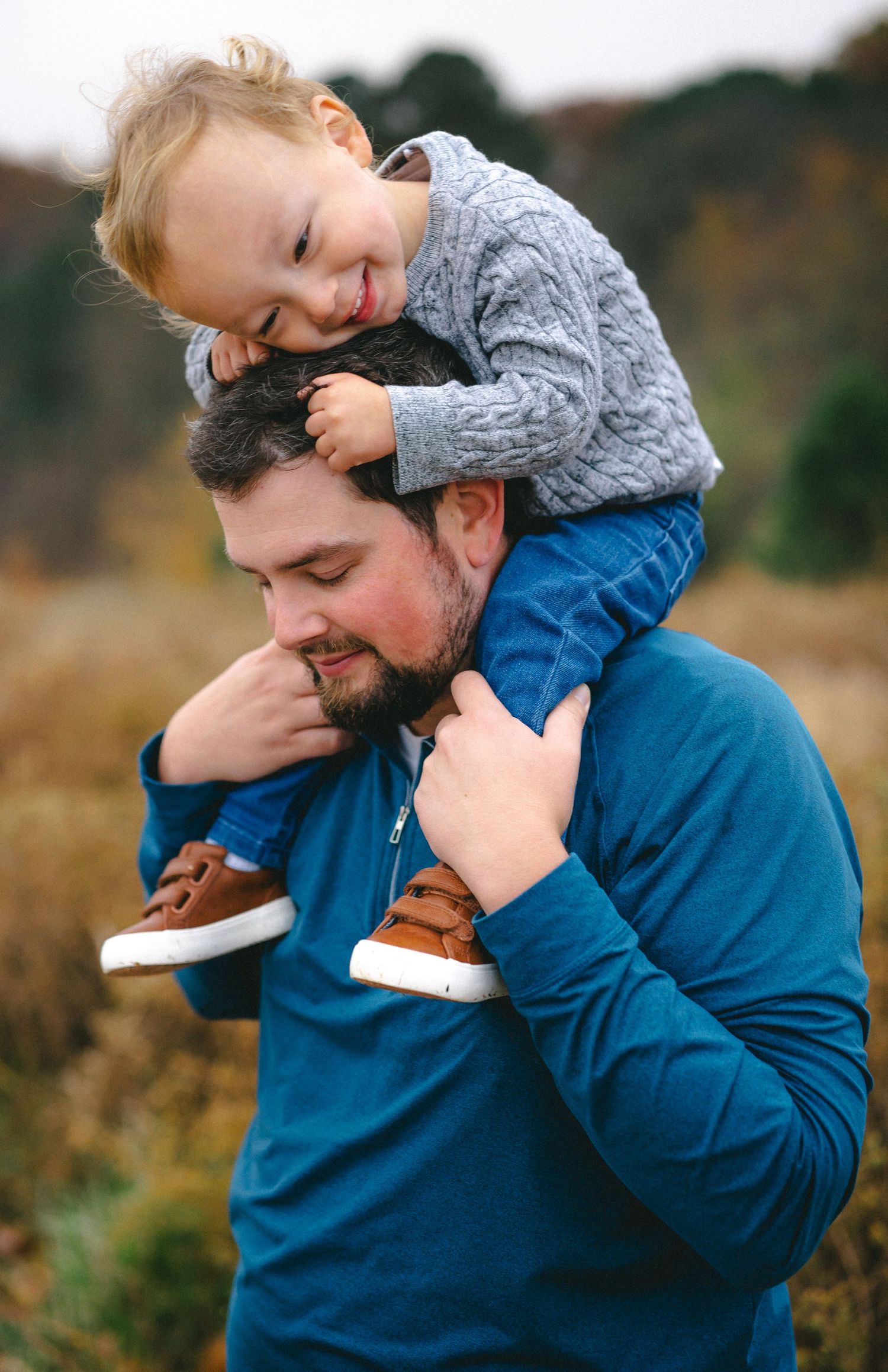 A tender moment between parent and child playing outdoors in casual clothing.