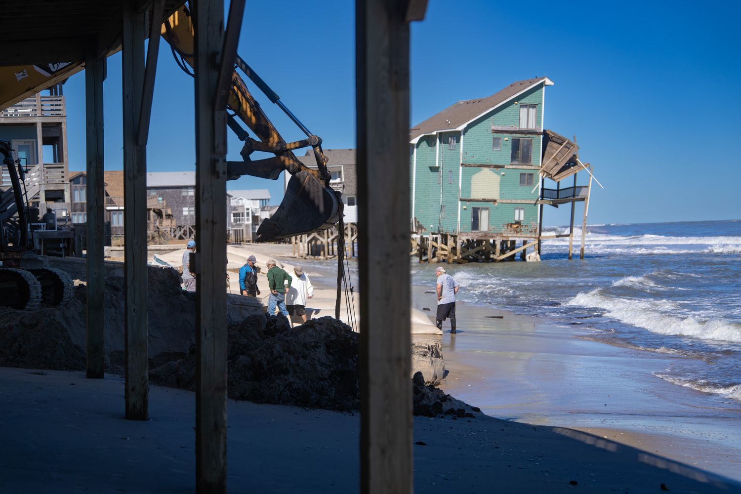 Beach houses on stilts along coastline with crashing waves. Buxton, North Carolina. Outer Banks.