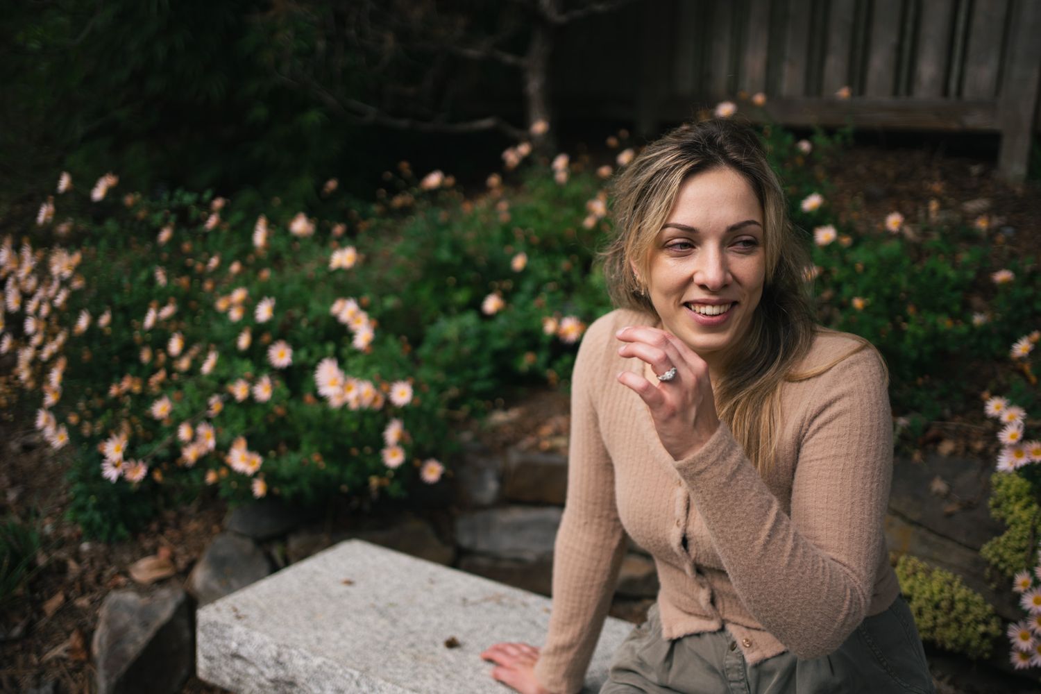 Casual outdoor photoshoot on stone wall with natural lighting.
