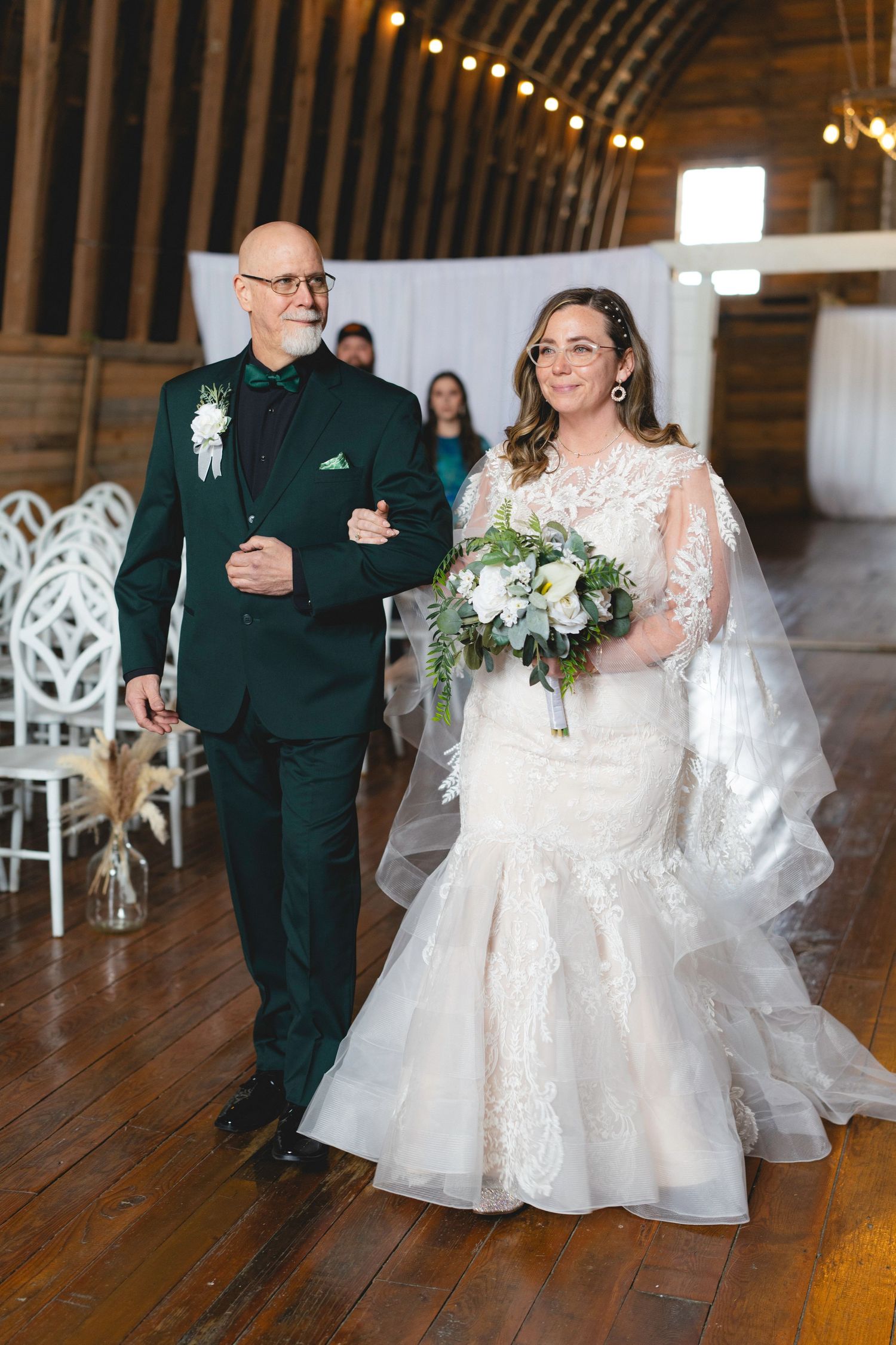 Wedding ceremony moments in a barn venue with forest green and white decor details.