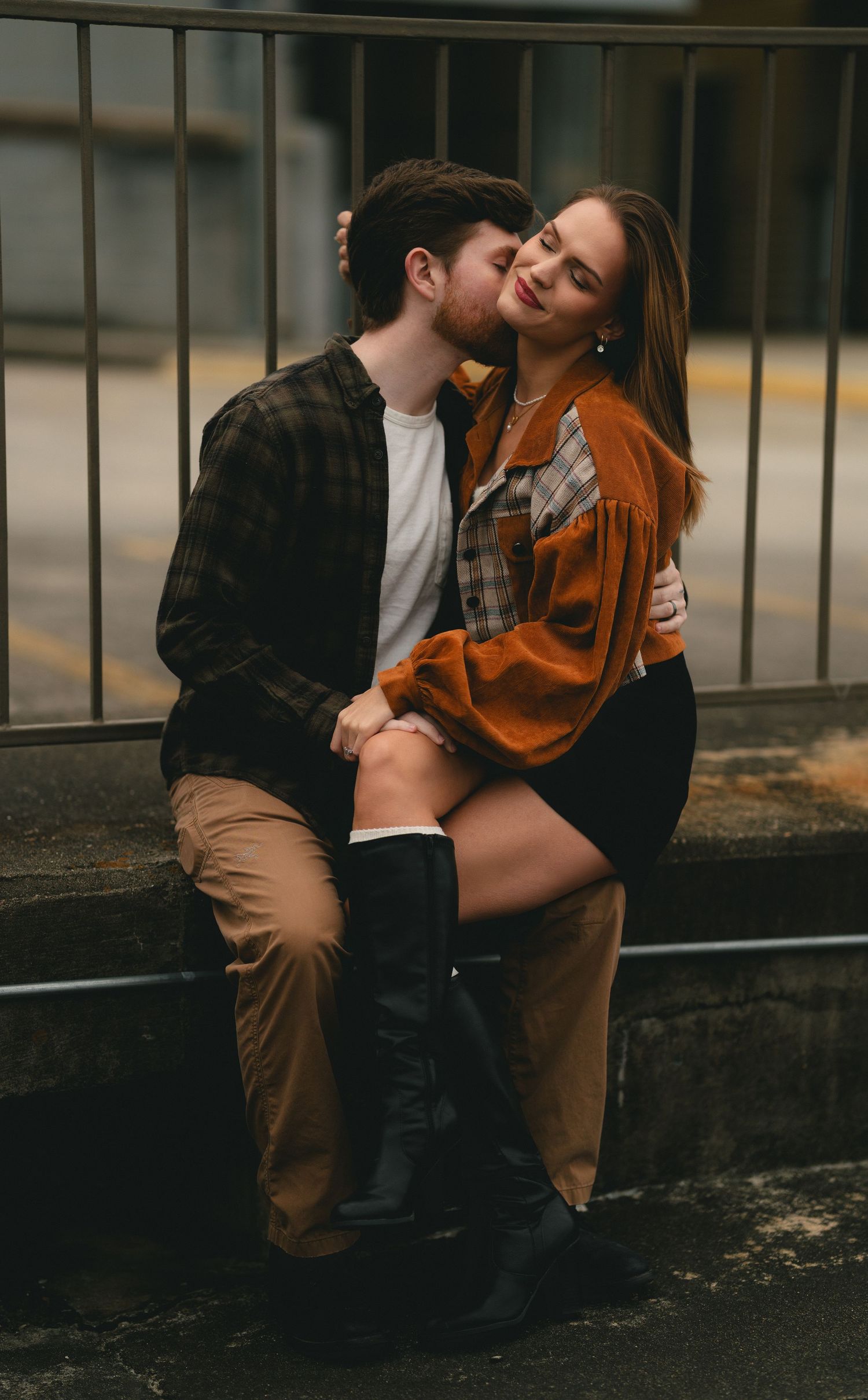 An intimate family moment captured against an urban backdrop with warm lighting.