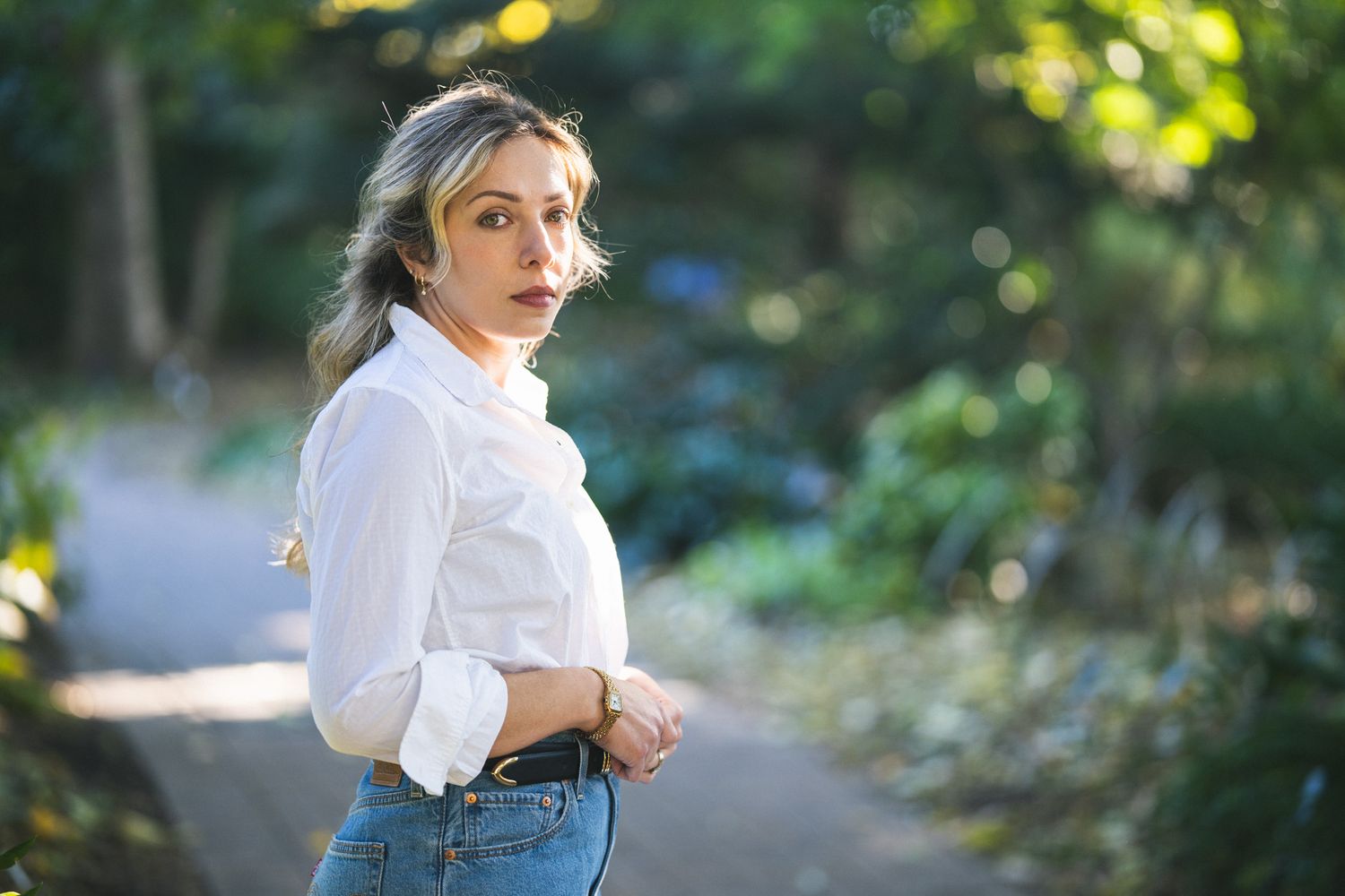 Sunlit outdoor portrait session in natural setting with bokeh effect.