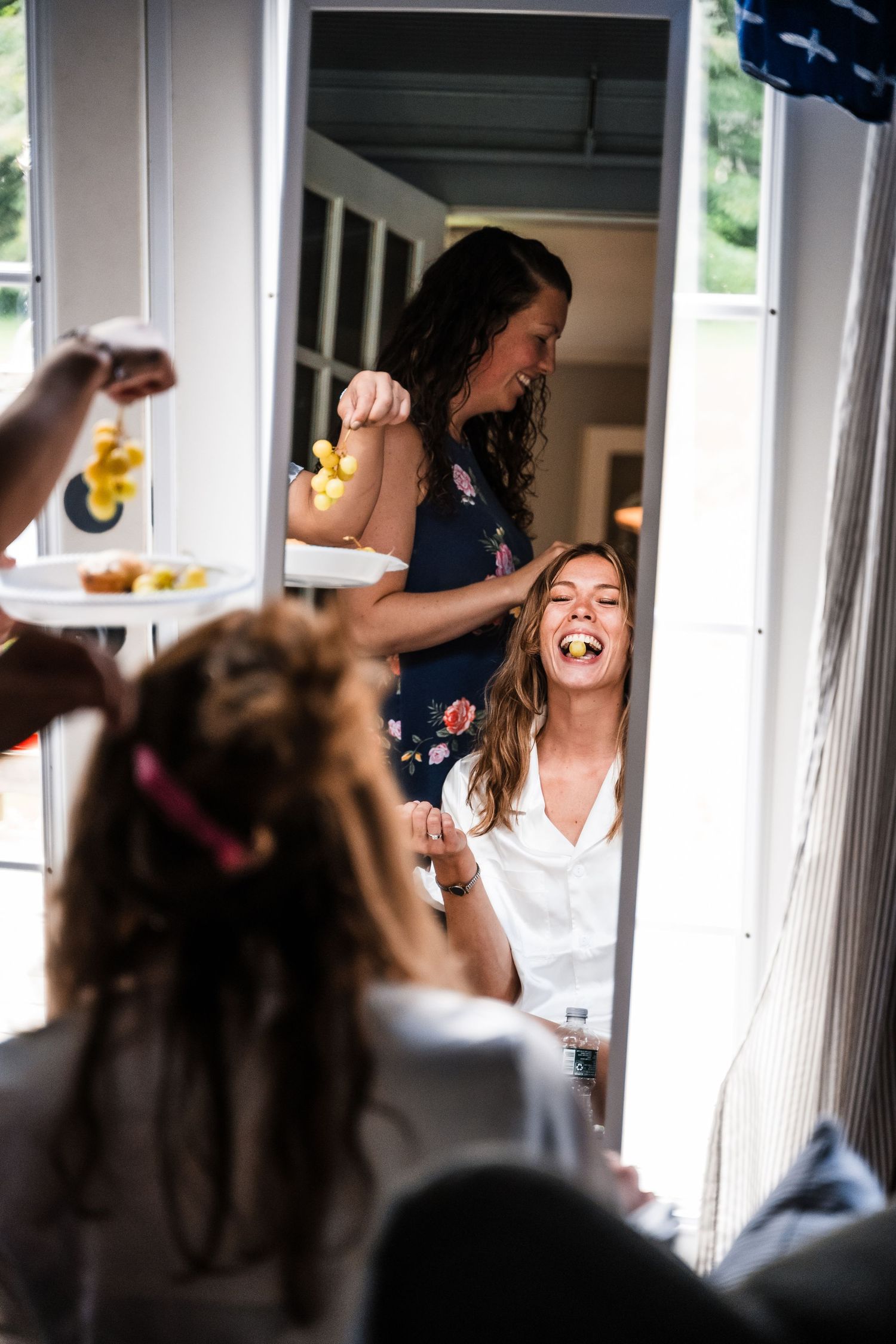 Wedding party members laugh and celebrate during pre-ceremony preparations.