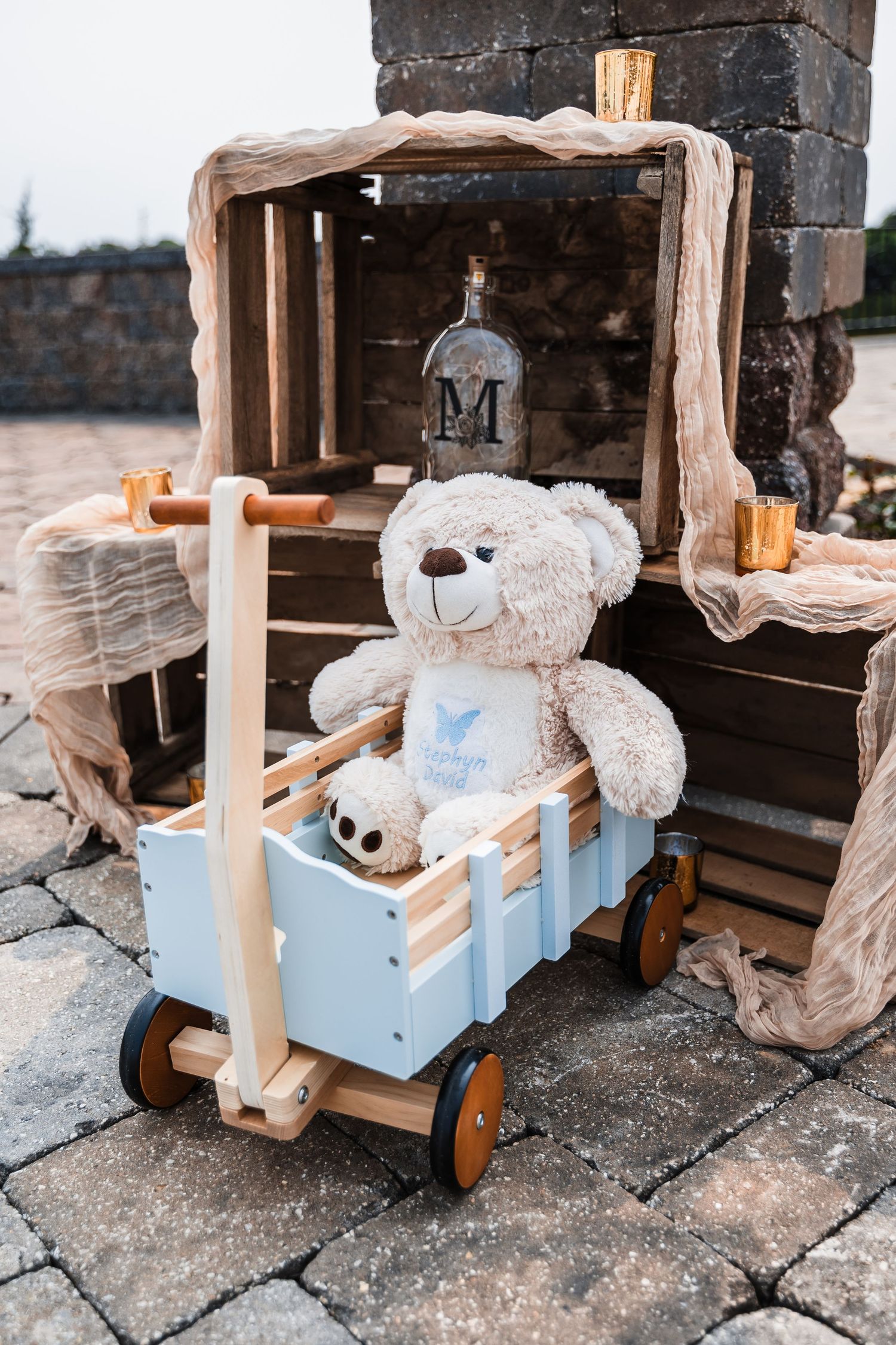 Sequence of photos showing a weathered stuffed teddy bear perched on a small blue wooden cart against distressed stone surfaces.