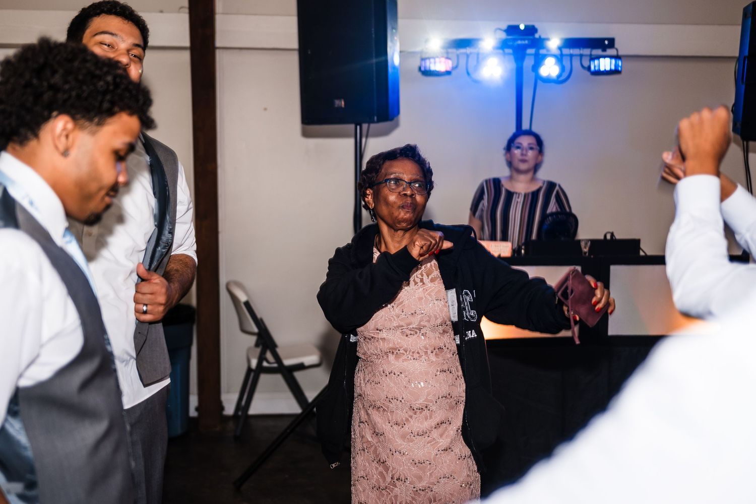 Energetic dance party with guests and DJ performing at wedding reception.