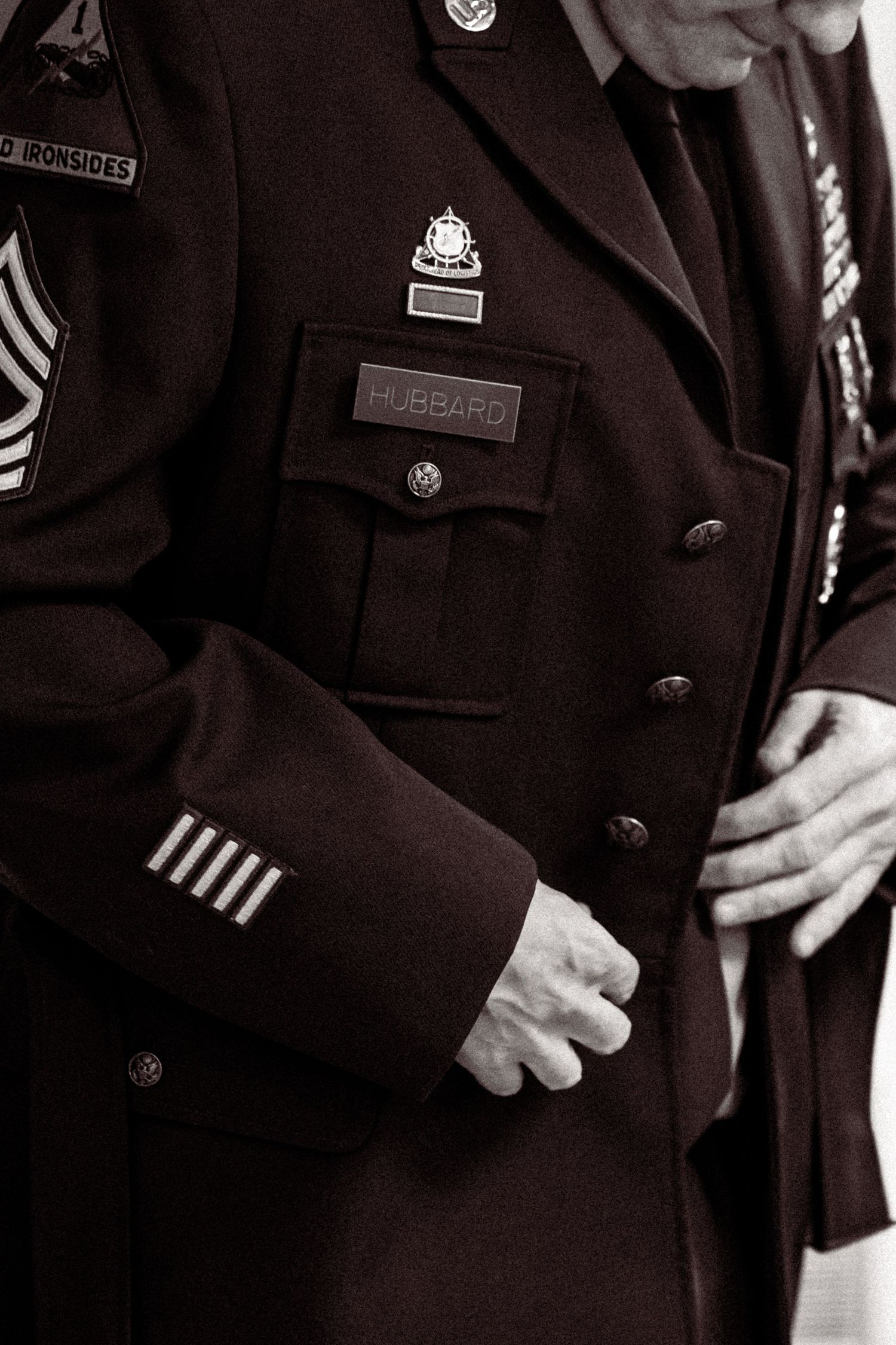 Close-up detail of a formal military dress uniform showing rank insignia and name badge.