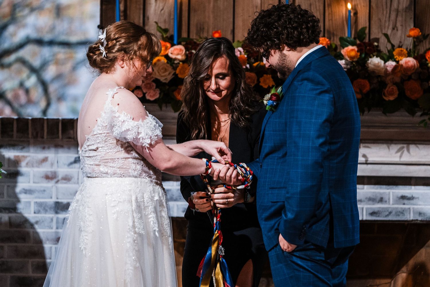 Intimate wedding ceremony with couple exchanging rings during handfasting ritual.