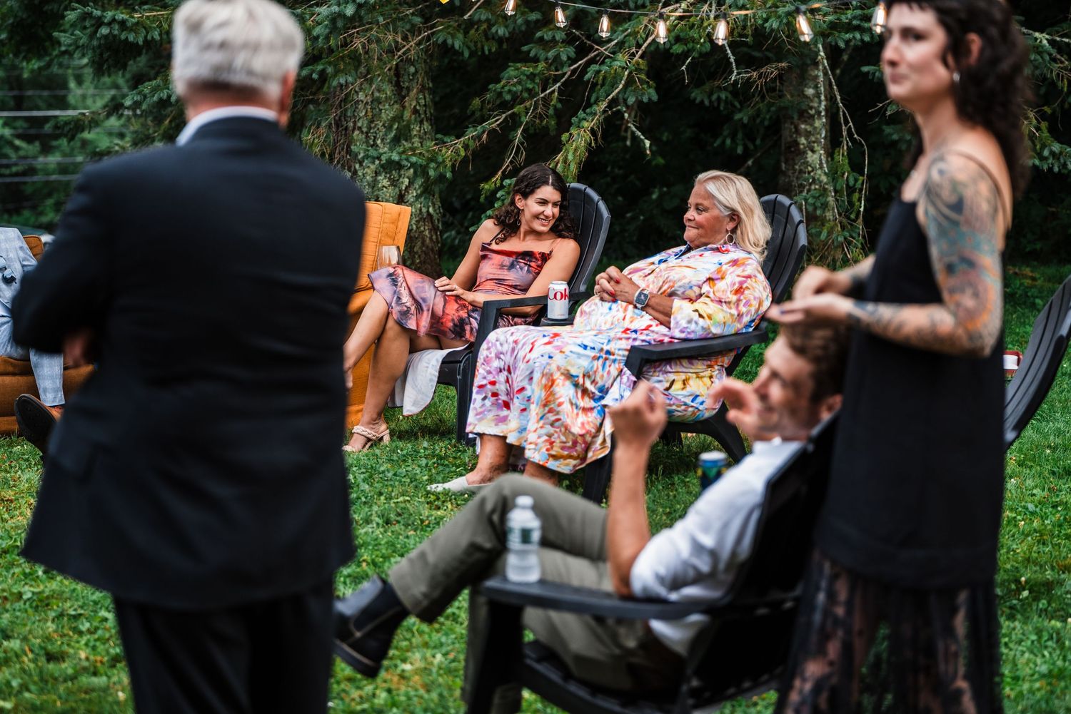 Wedding guests enjoying an outdoor celebration in garden chairs.