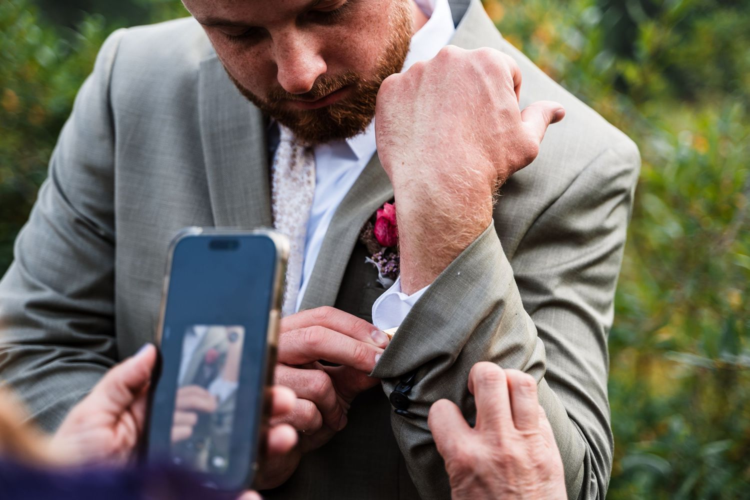 Close-up shots of someone looking at photos on a mobile phone during an outdoor event.