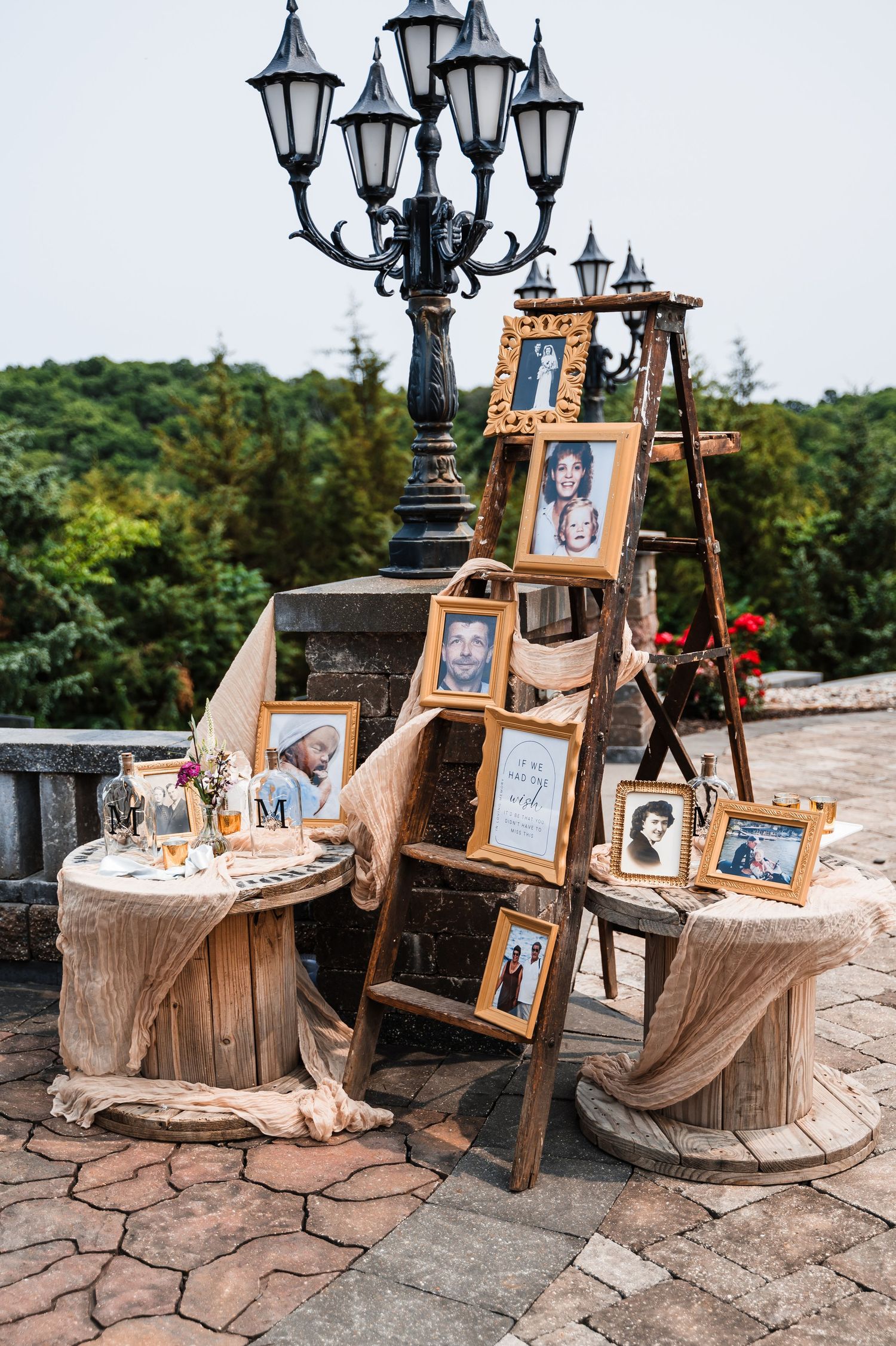 Romantic outdoor wedding display with vintage lanterns and wooden spool tables at dusk.