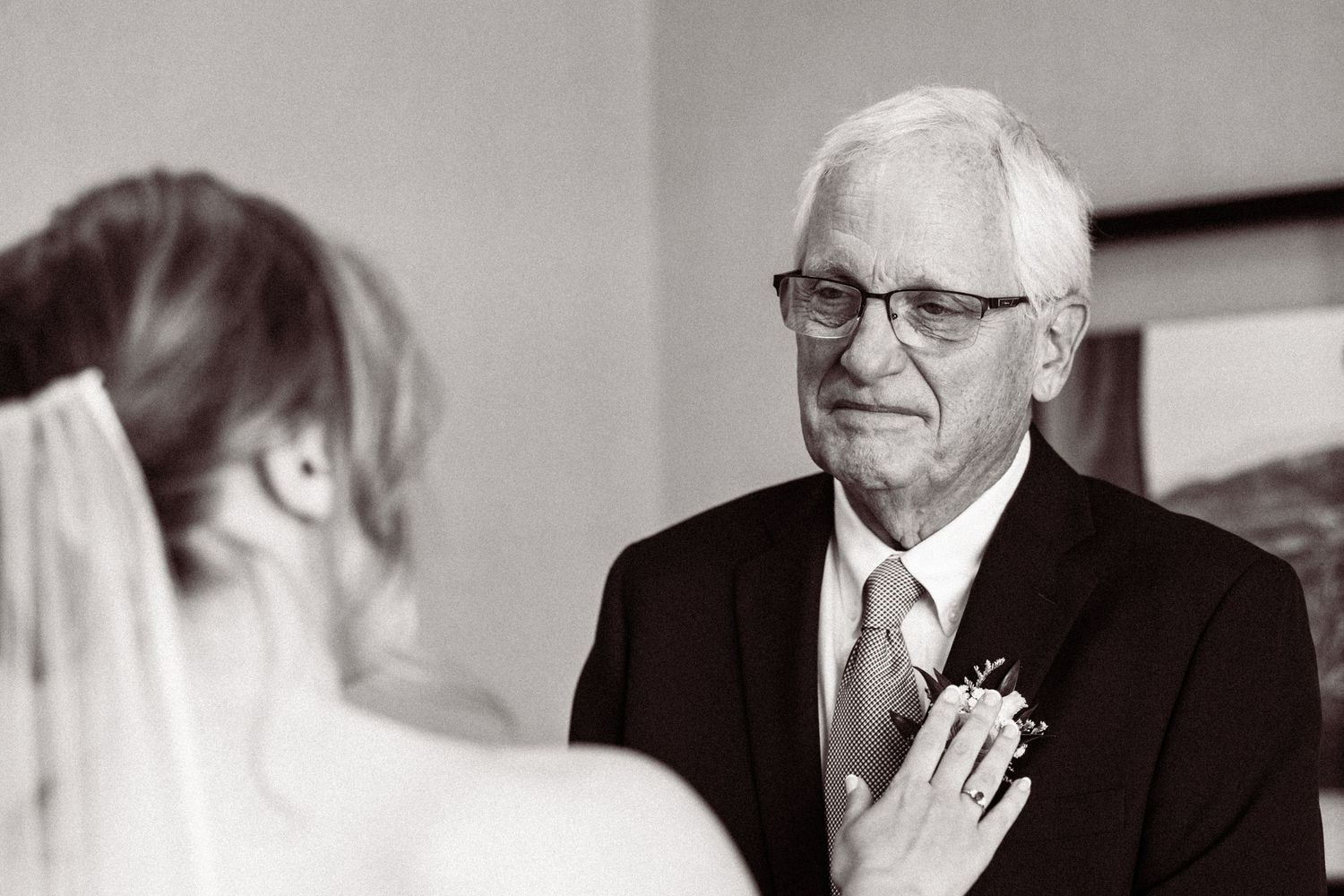 Emotional father sees bride daughter for first time on wedding day in black and white photo.