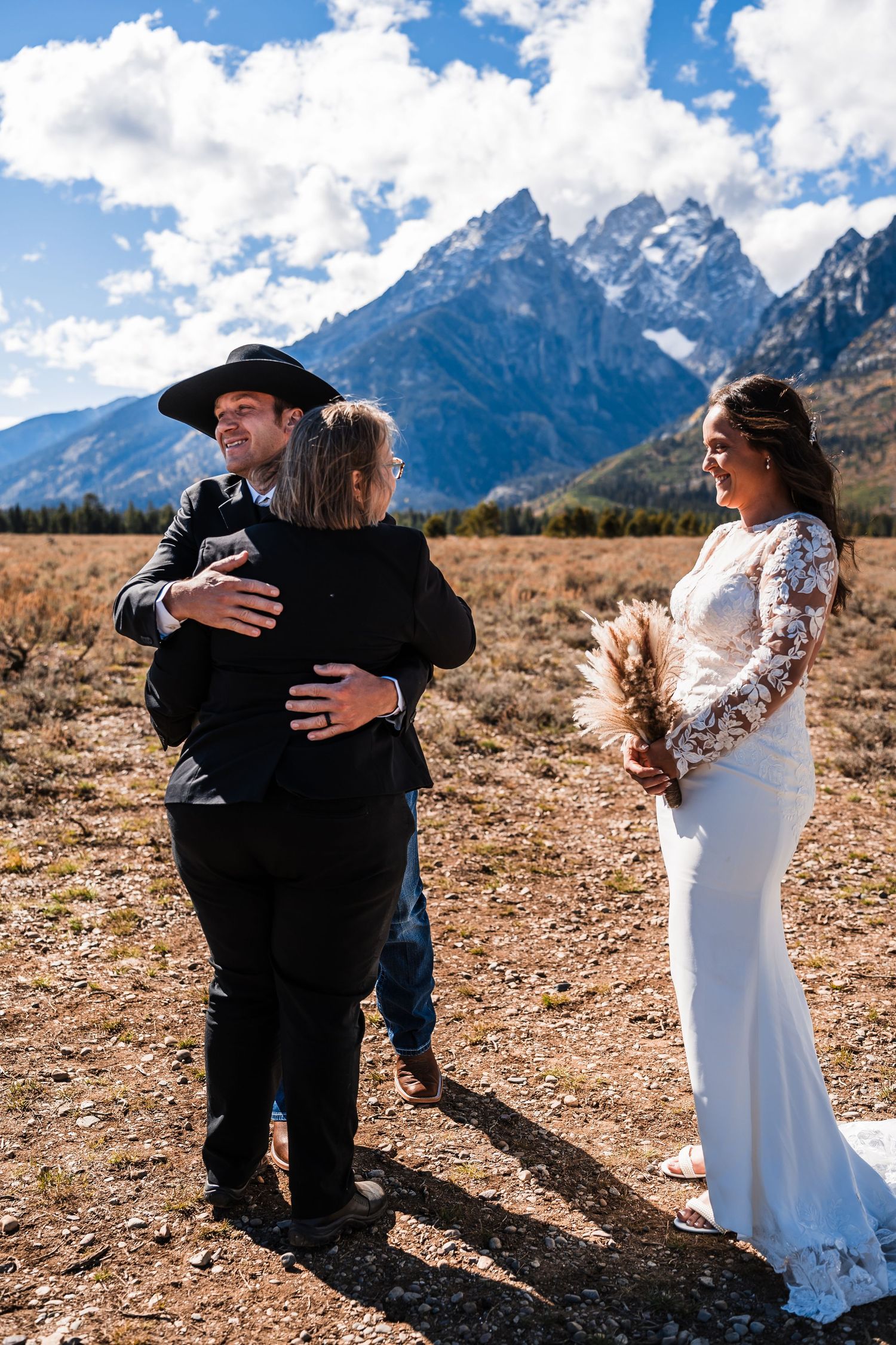 Emotional embraces shared during a mountain wedding ceremony with dramatic peaks in the background.