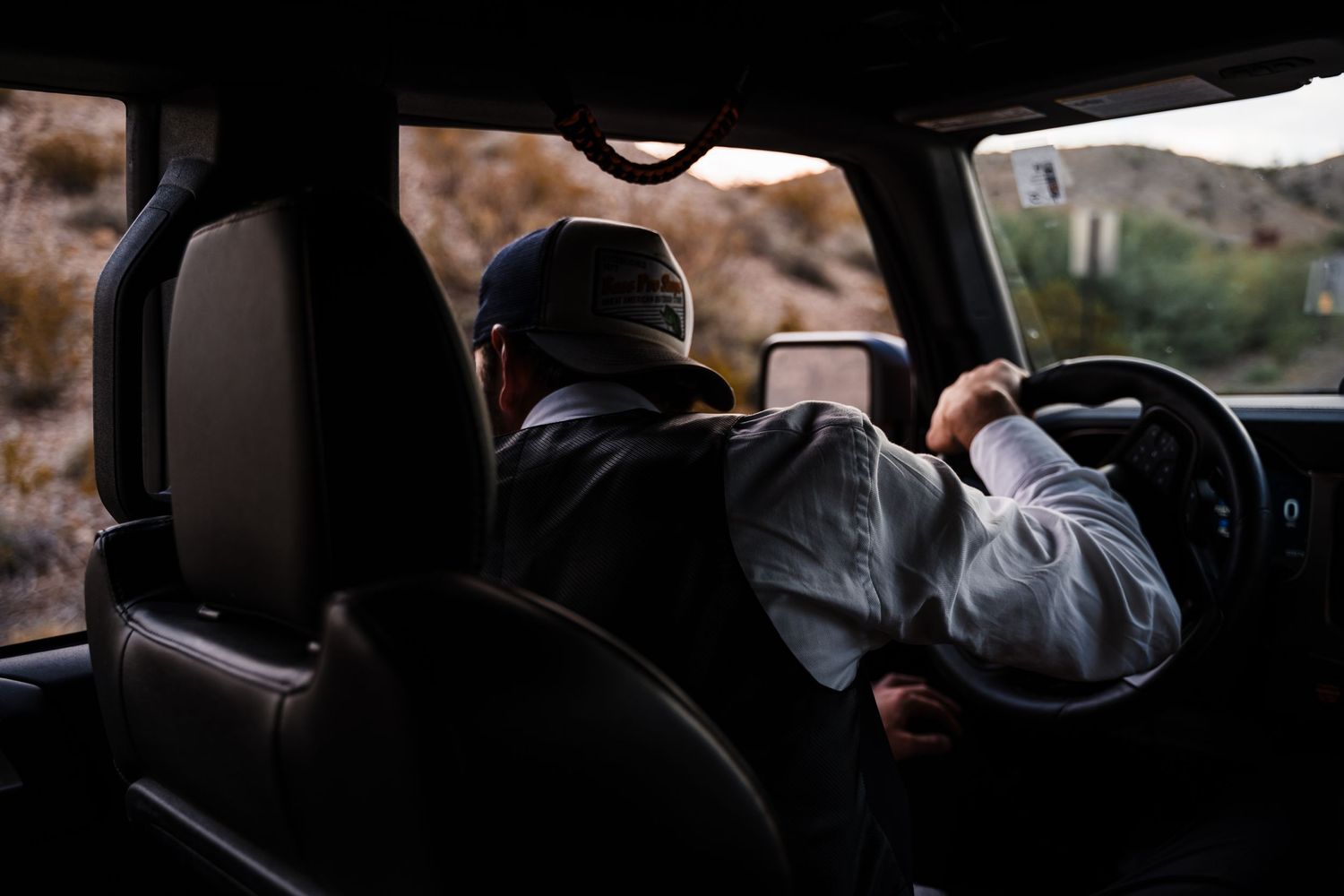 View from back seat of someone driving through a scenic area.