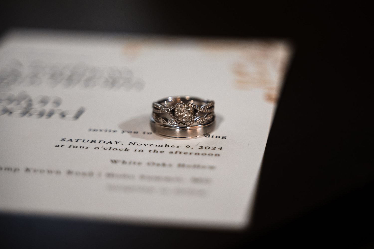 Wedding rings photographed on an invitation with shallow depth of field.