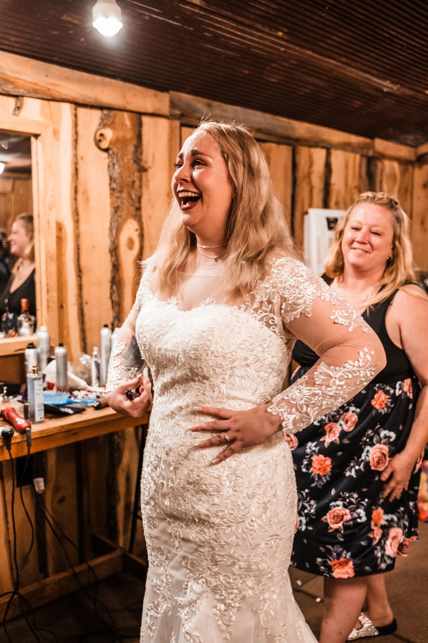 Joyful candid moment of celebration in rustic wooden barn getting ready room.
