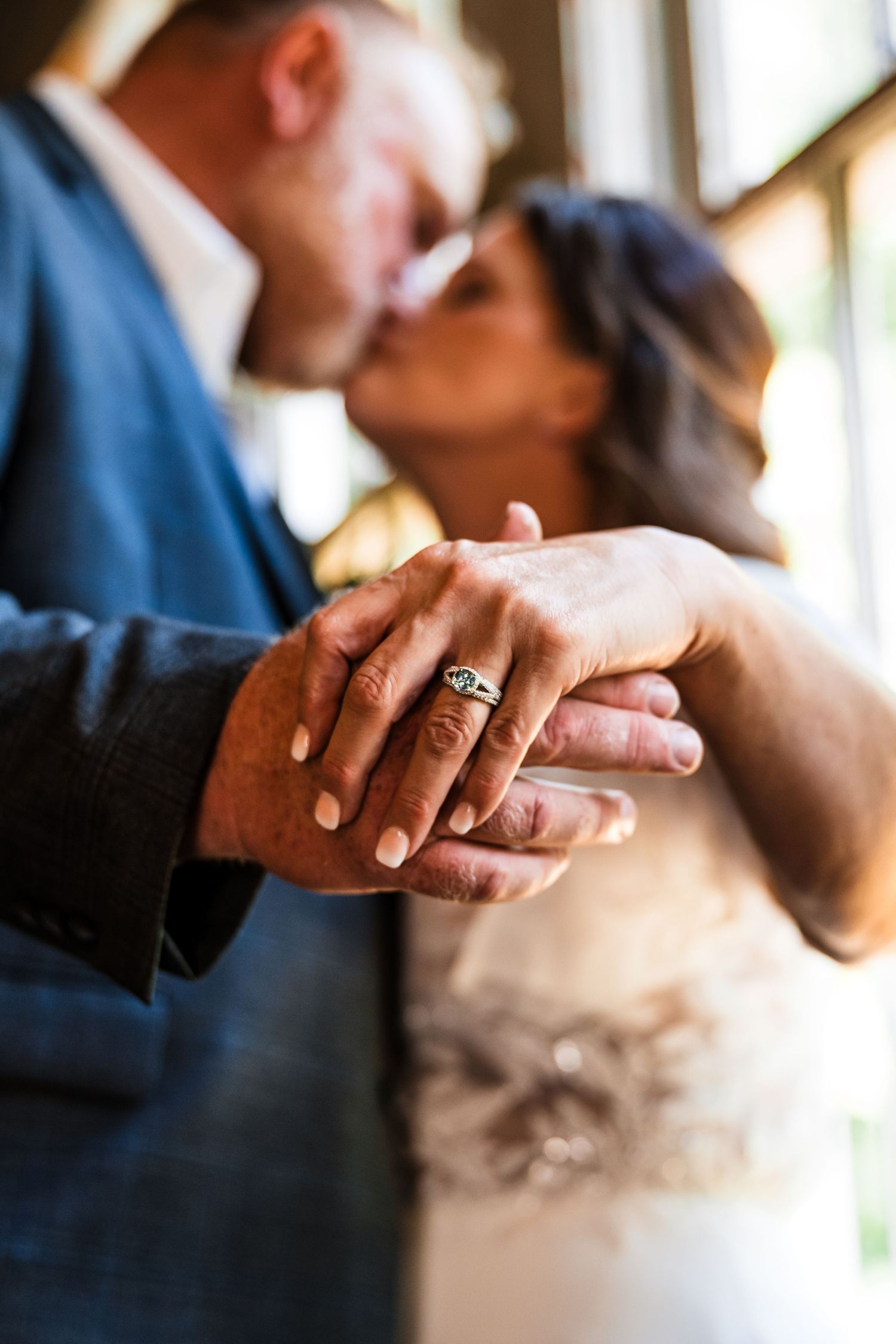 Close up of hands with wedding rings as newlyweds share an intimate moment together.