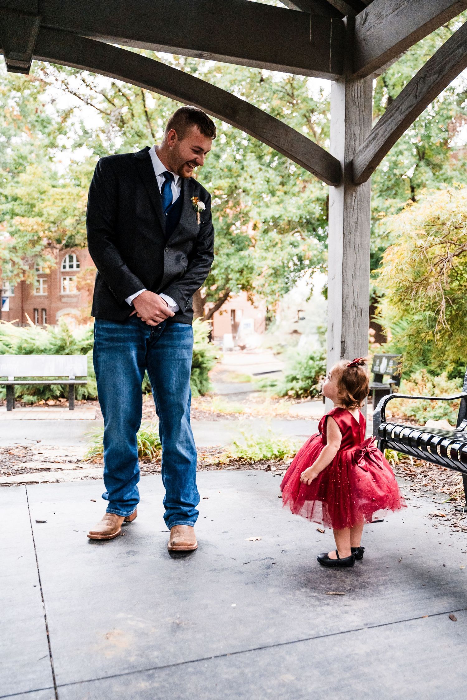 Playful interaction sequence captured under covered walkway with red tulle dress.