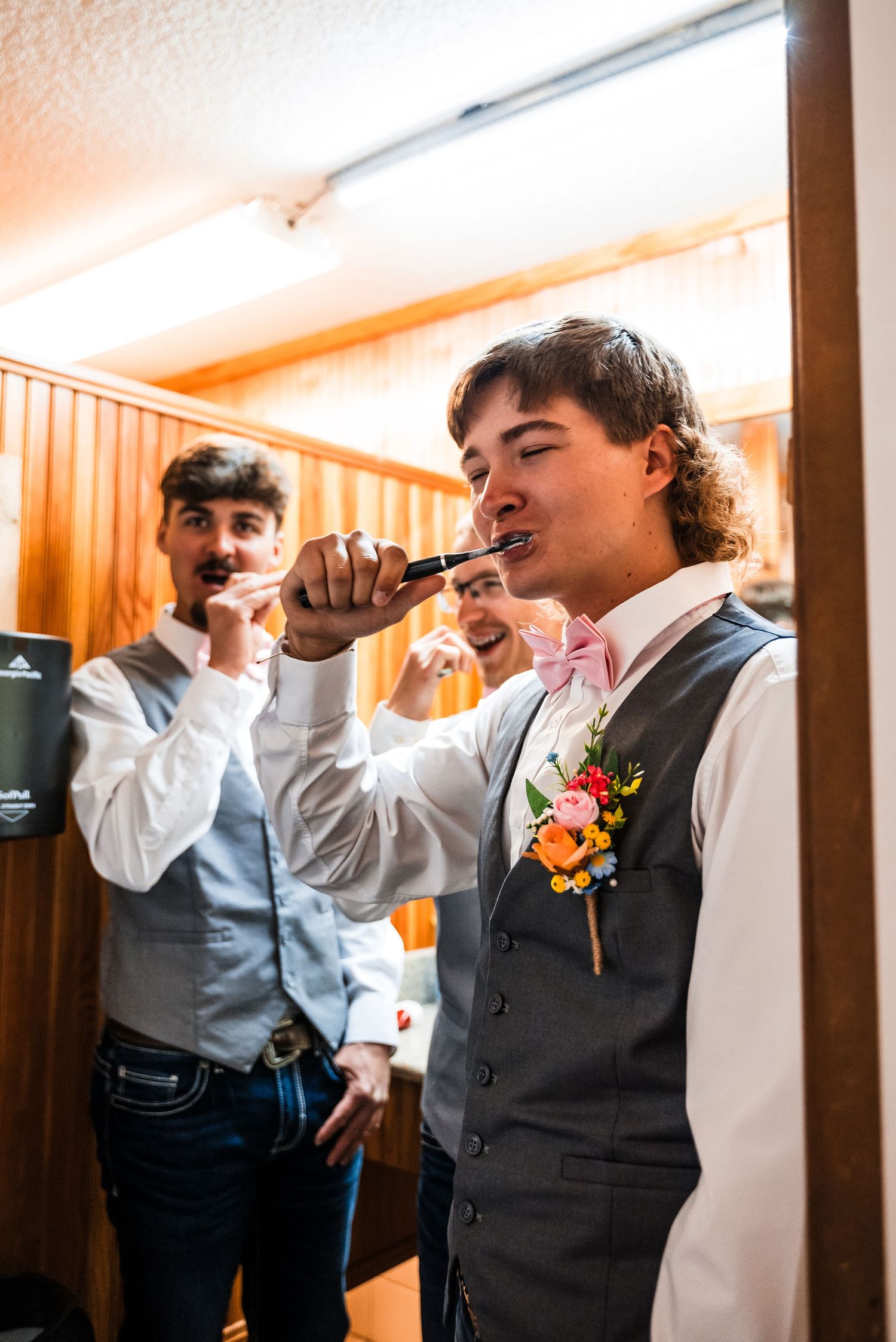 Groomsman in vest and bowtie sings karaoke while getting ready.