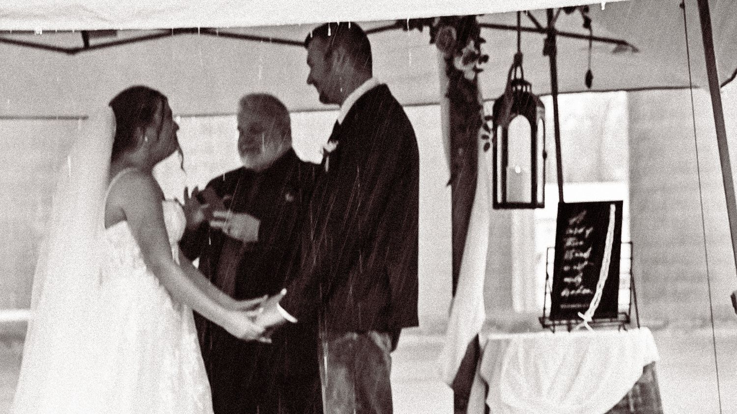 Wedding reception guests dance and celebrate in a dimly lit venue.