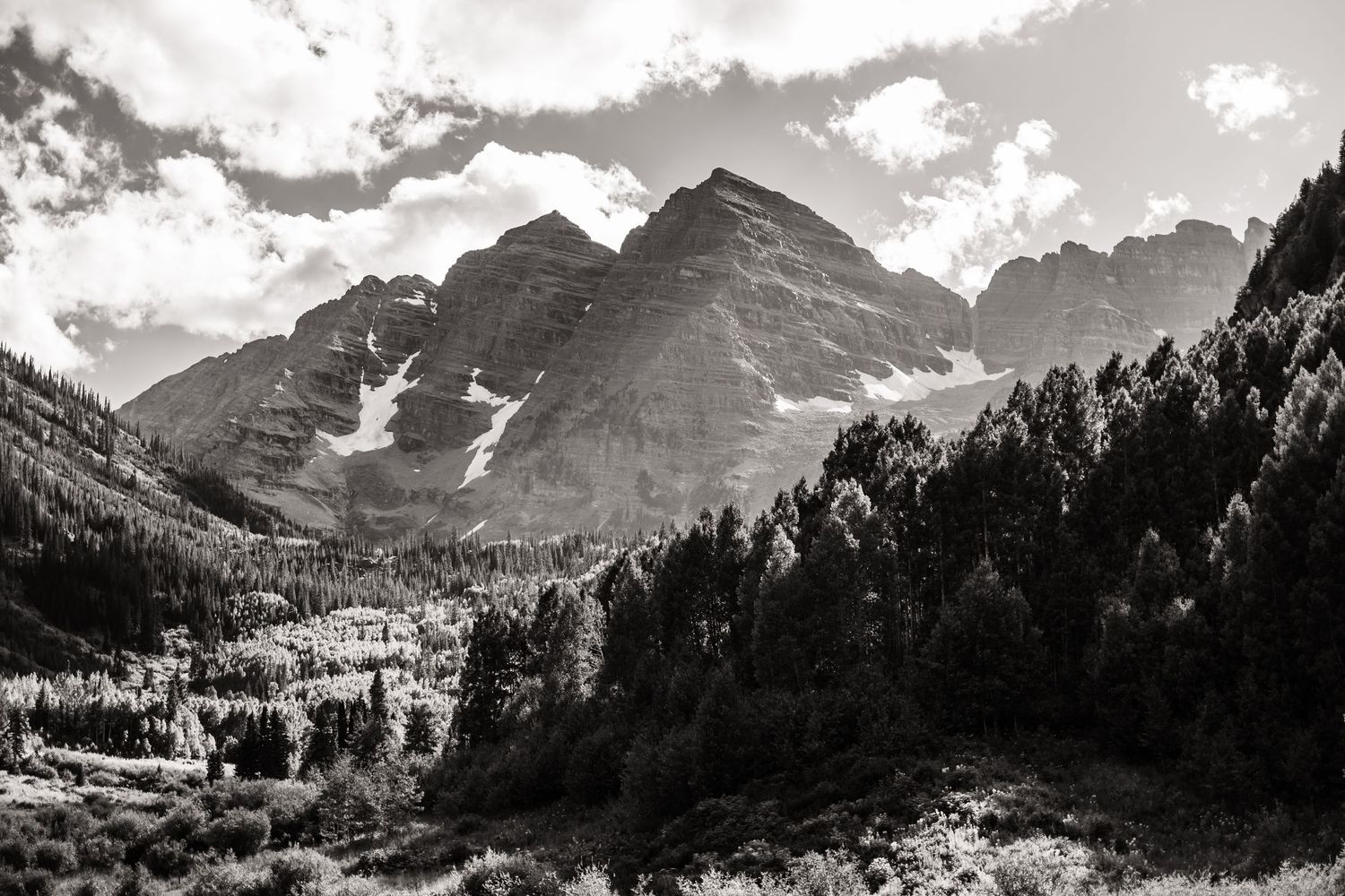Black and white mountain landscape with dramatic clouds and rugged peaks.