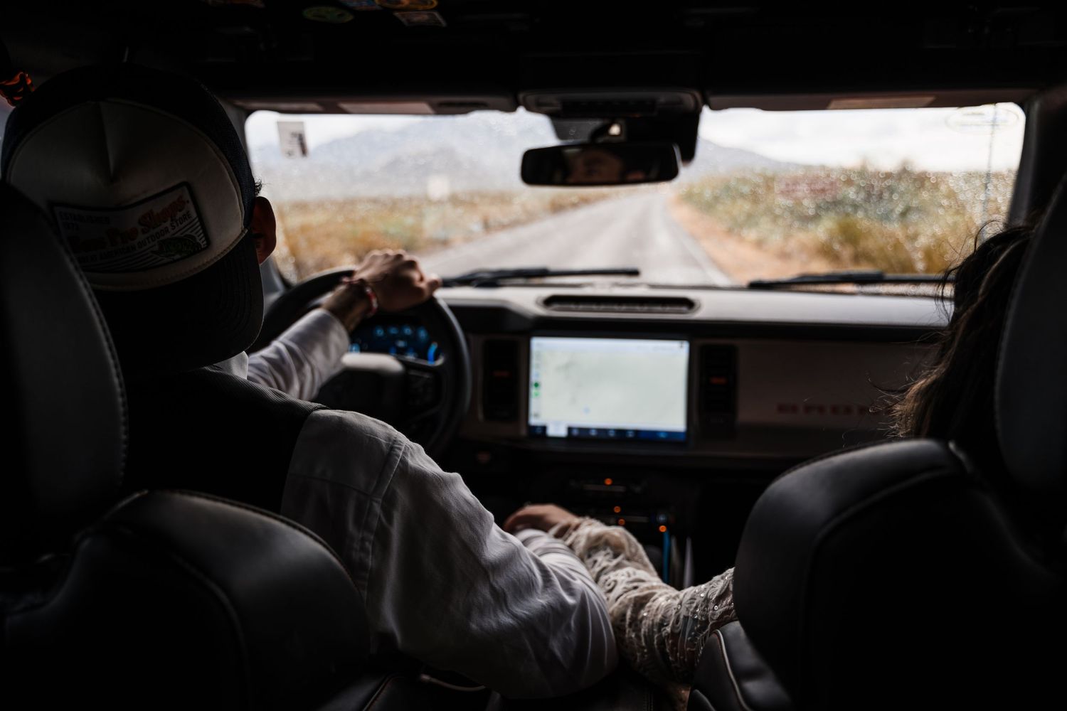 Interior view of car dashboard and windshield while driving on open road.