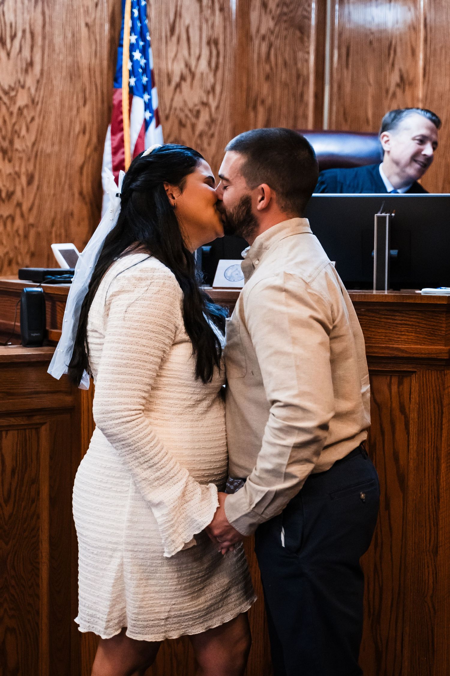 An intimate courthouse ceremony moment with an American flag in the background.
