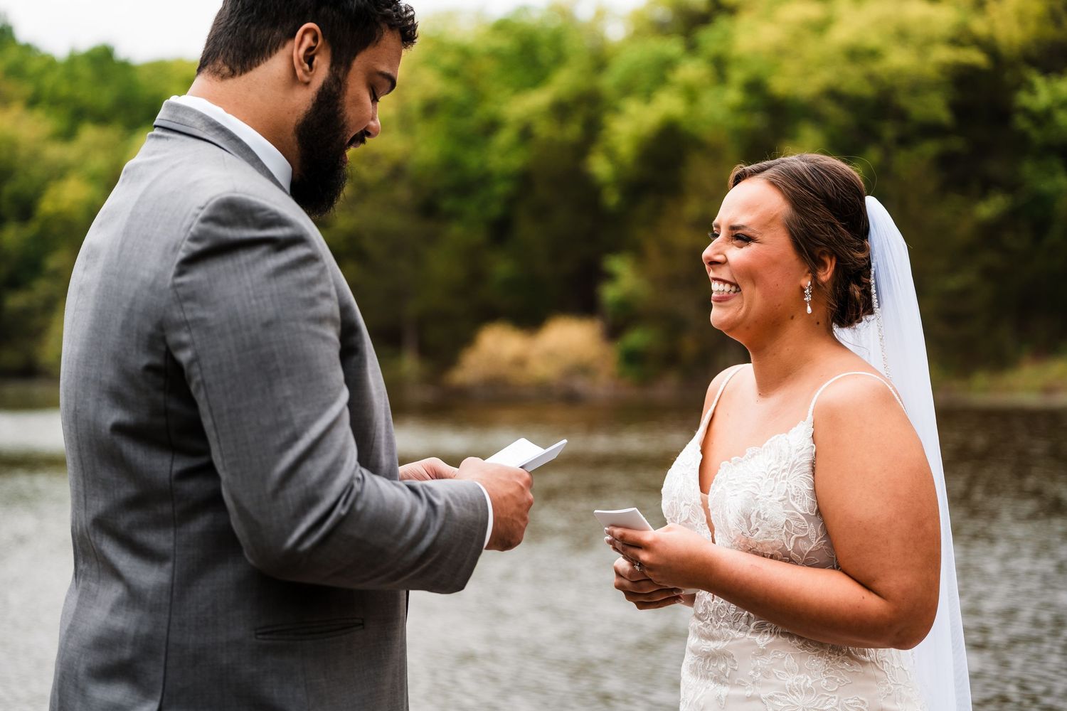 A couple exchanges vows and rings during an intimate outdoor wedding ceremony by the water.