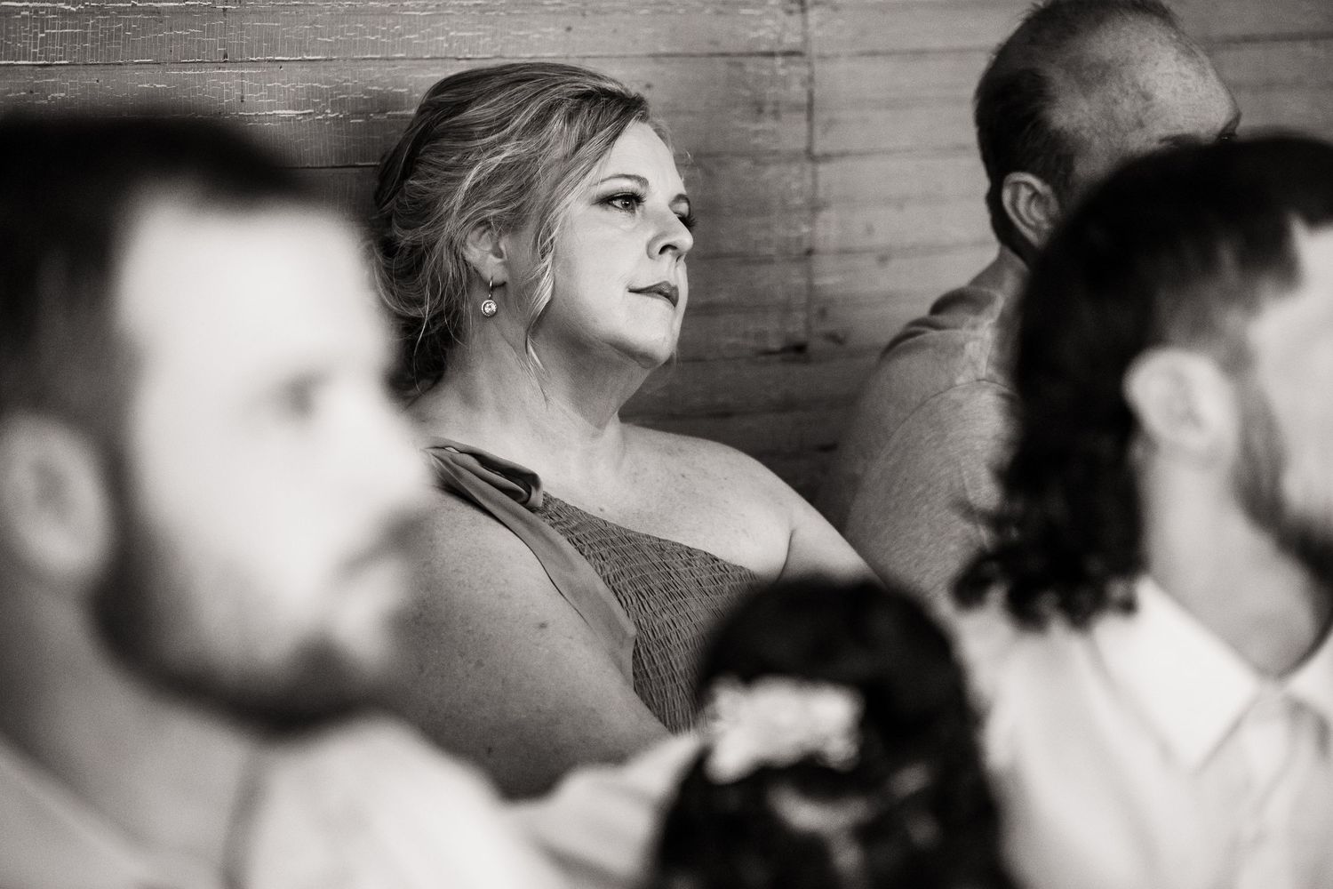 Black and white candid photo capturing emotional wedding ceremony reactions.