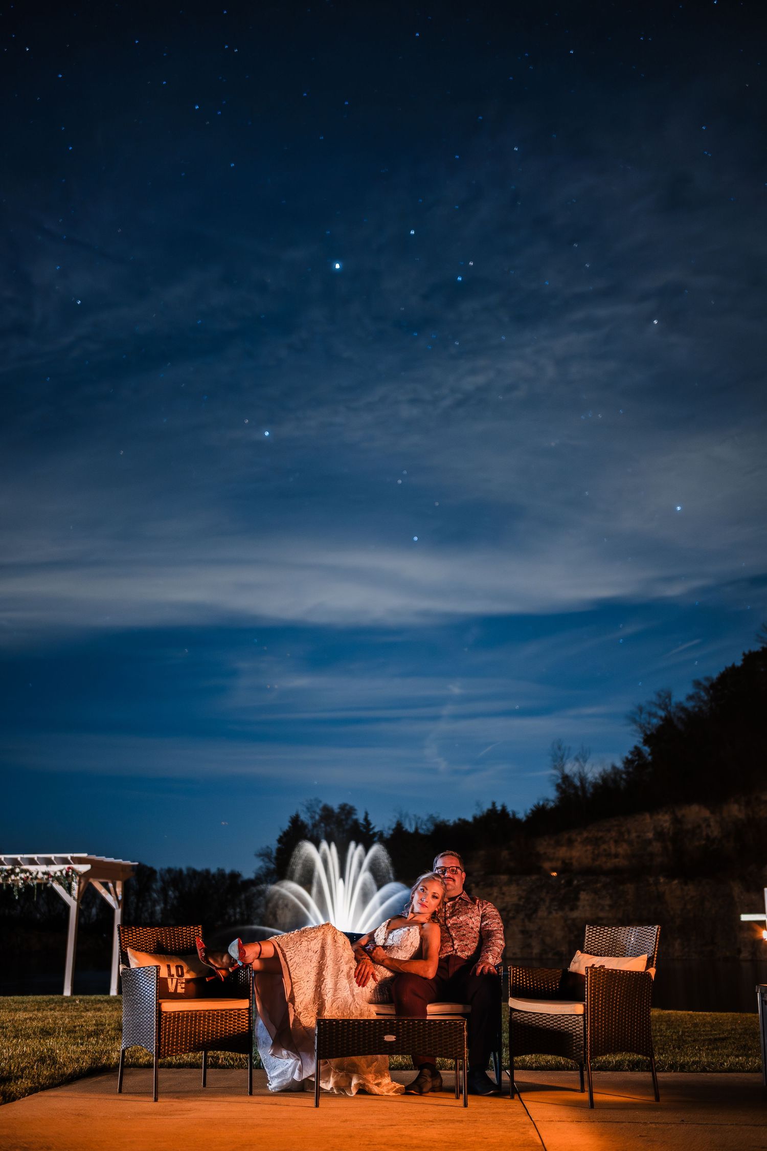 Outdoor lounge area with illuminated furniture under a starry night sky.