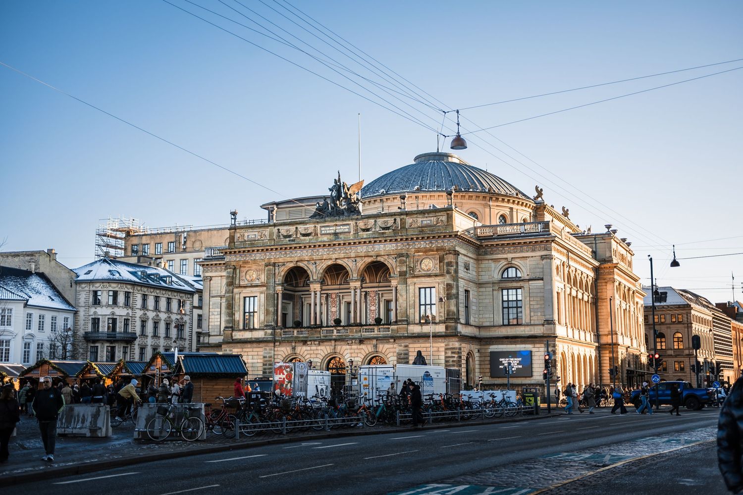 Historic railway station building with ornate architecture photographed from multiple angles against a blue sky.