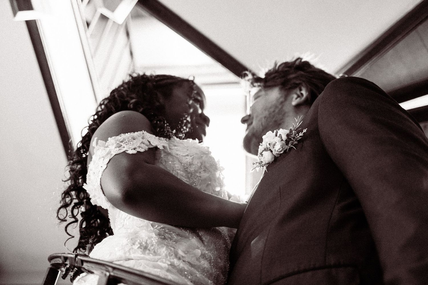 Black and white photo of bride and groom sharing intimate moment during wedding ceremony.