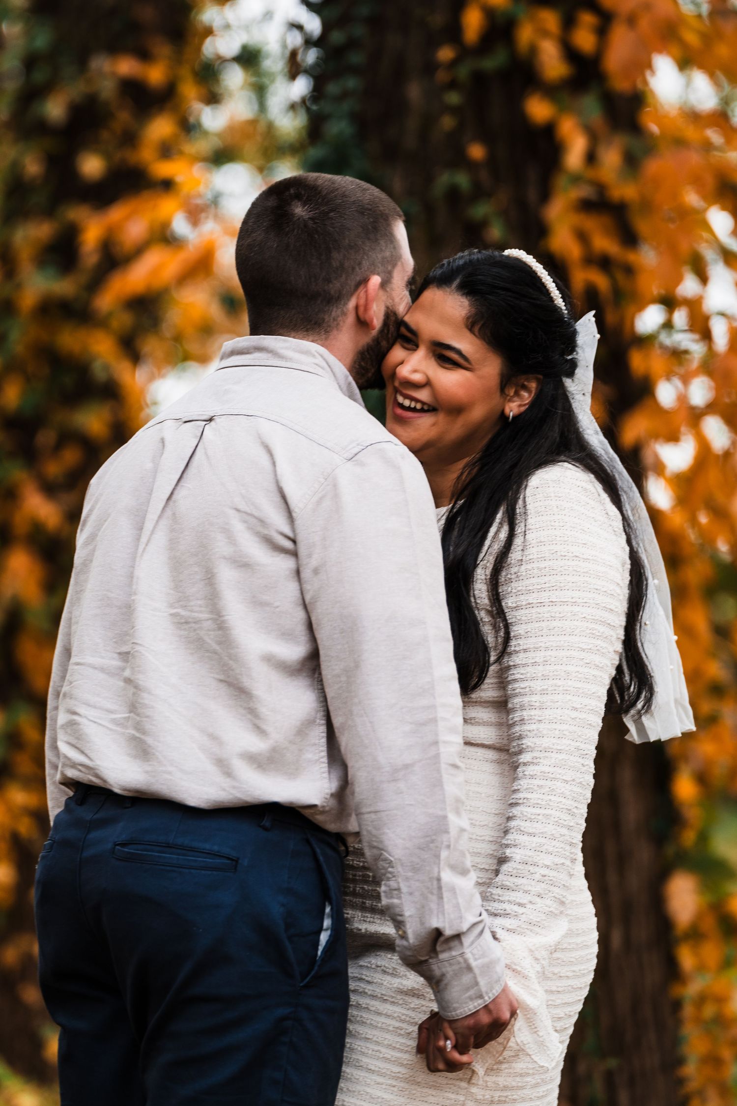 Happy couple sharing tender moment among fall trees.