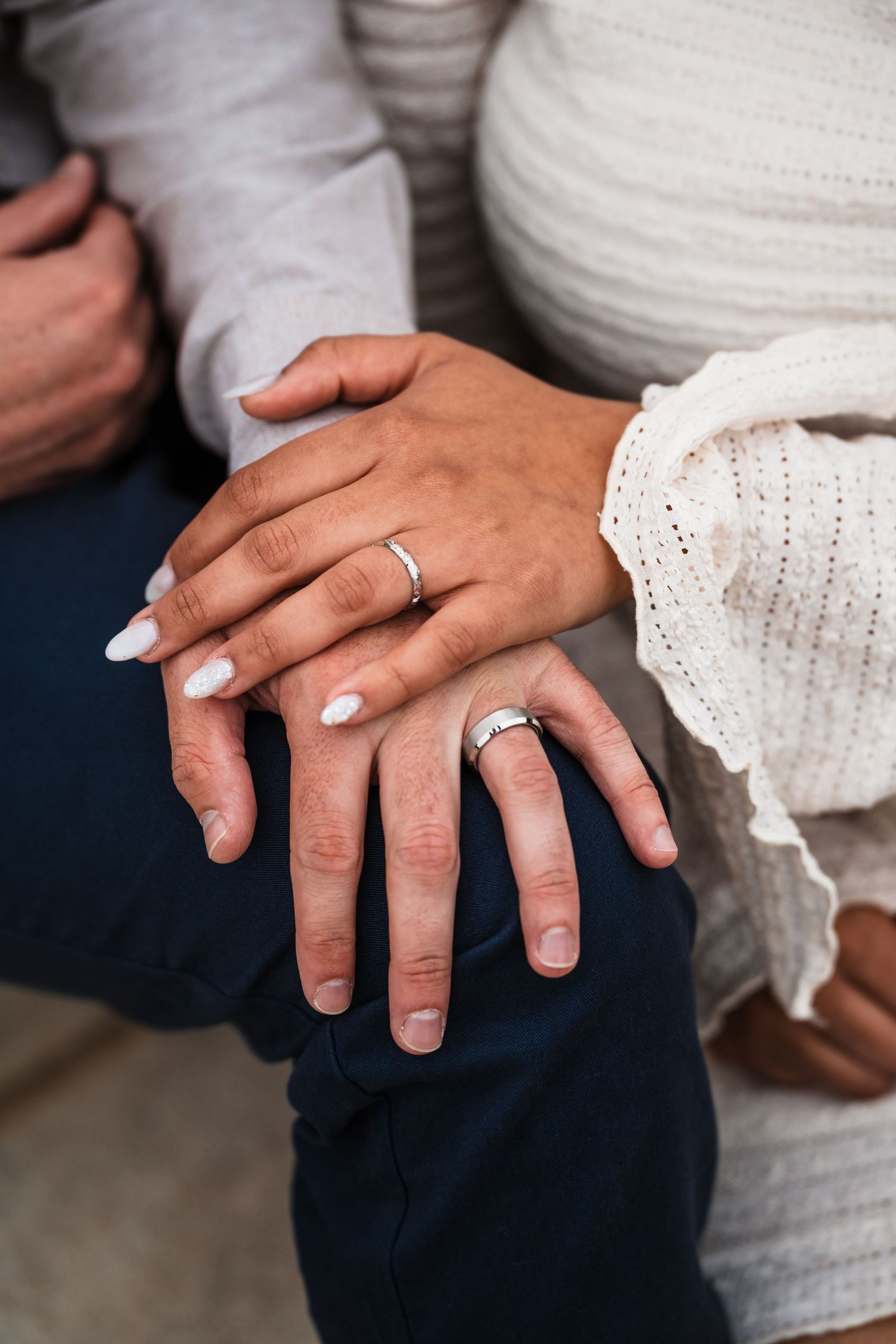 Close up of hands with wedding rings in casual intimate pose.