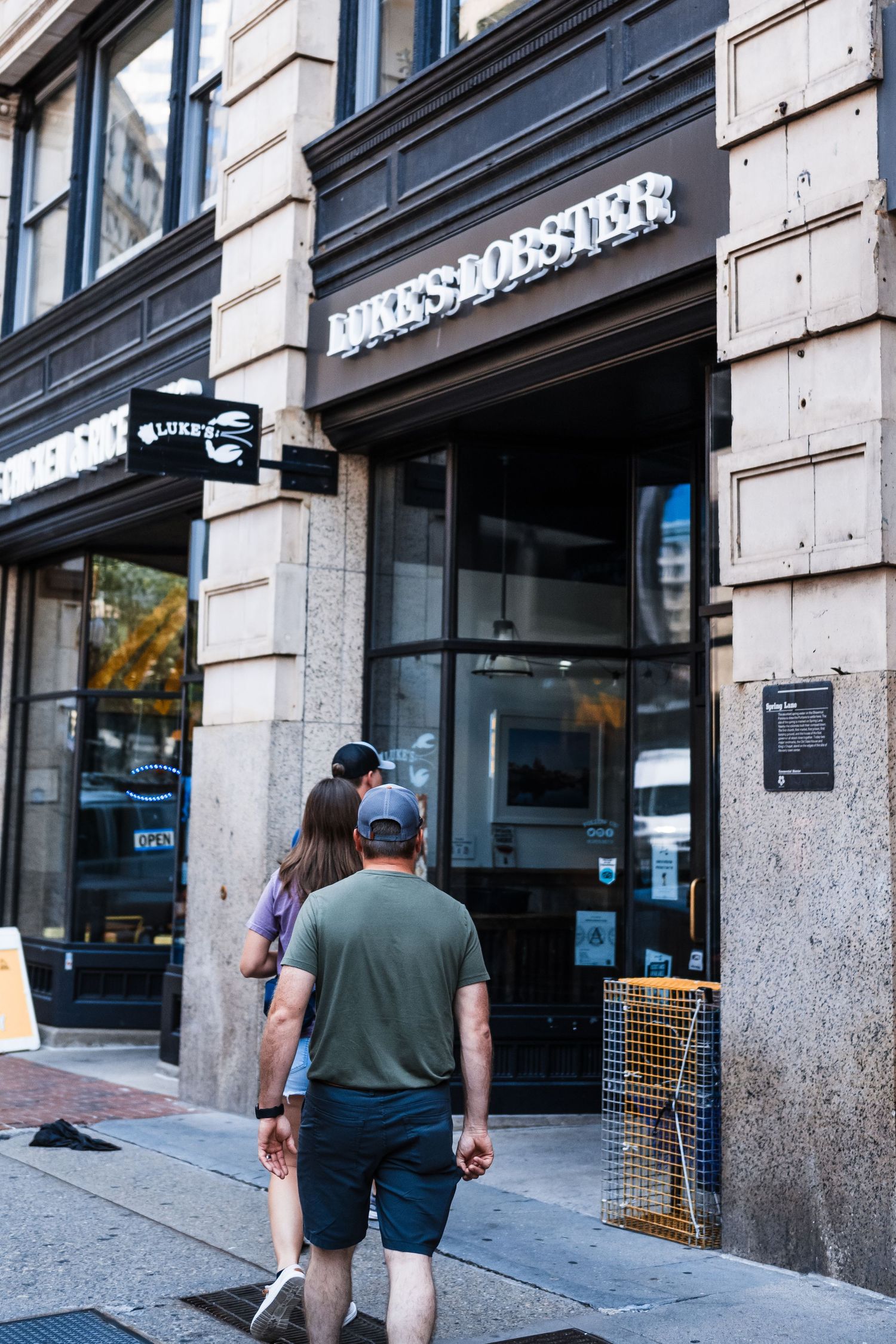 Pedestrians walk past the entrance of an Express clothing store in an urban setting.