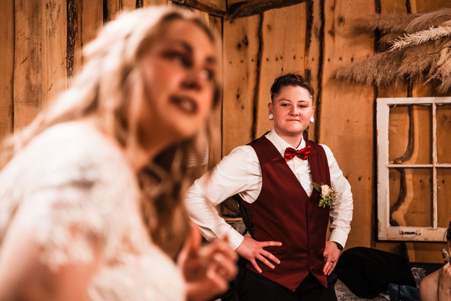 A candid moment captured inside a rustic wooden barn during wedding celebrations.