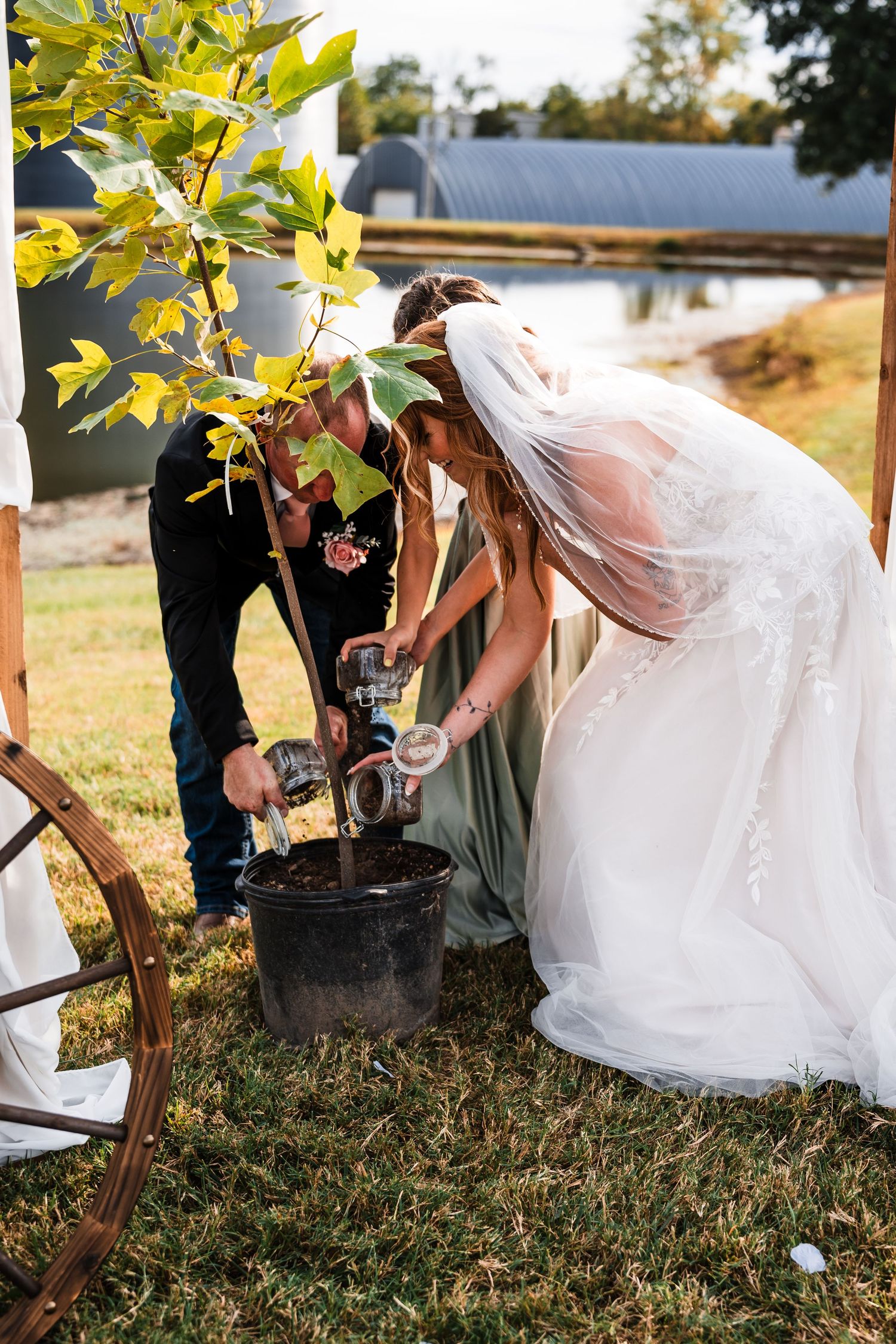 Wedding party participating in a tree planting ceremony during outdoor celebration.