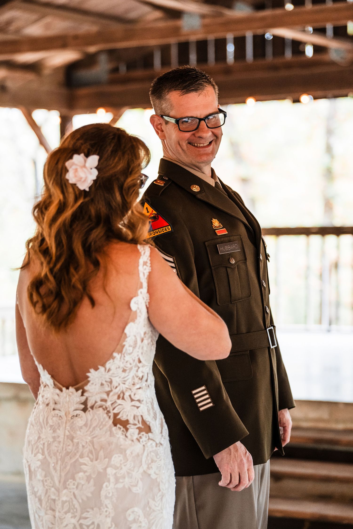 A wedding couple shares a moment together under a wooden pavilion during their ceremony.