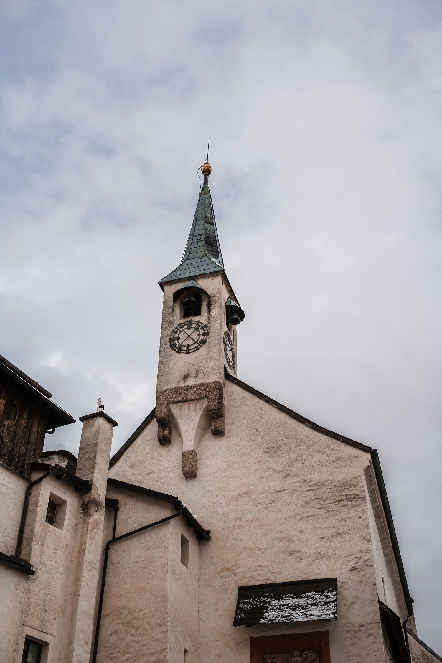 White church exterior with multiple bell towers and spires against an overcast sky.