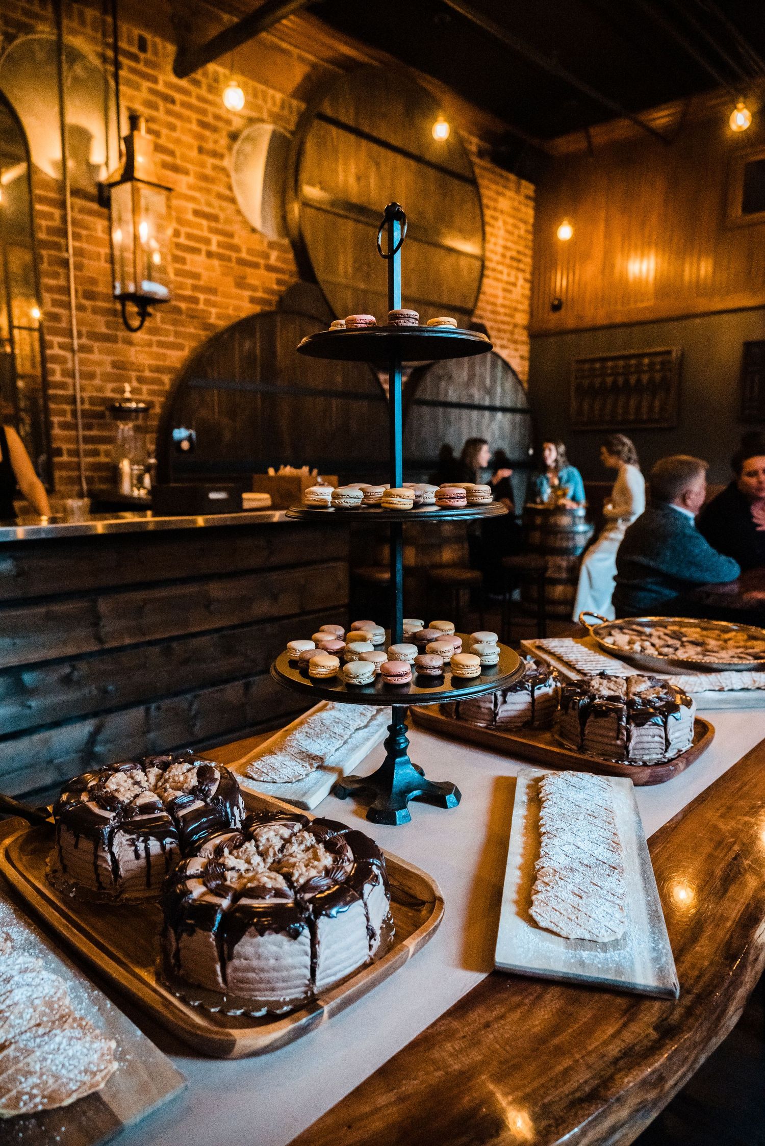 Rustic dessert table with chocolate cakes and treats displayed at a wedding reception.