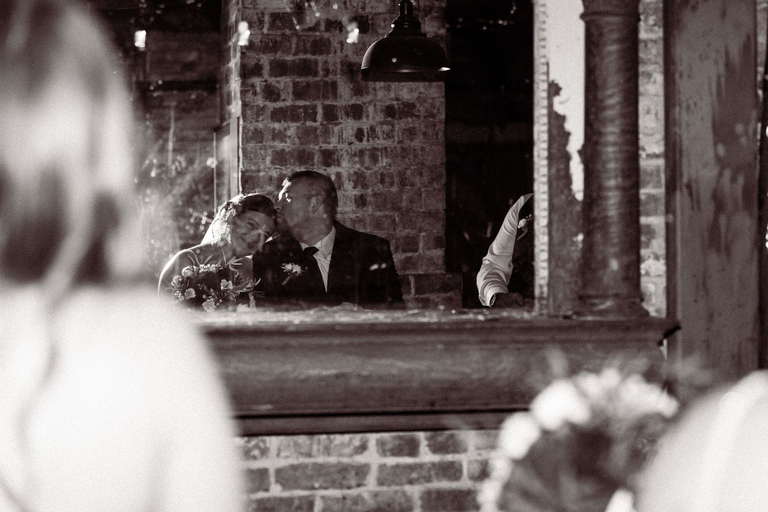 Rustic brick wall venue decorated with string lights creates an intimate wedding atmosphere.