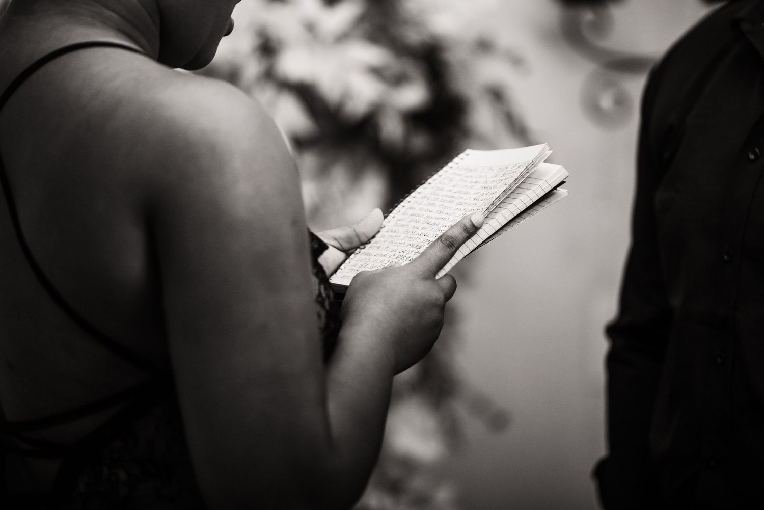 Someone reads a book while sitting in a black and white artistic portrait.