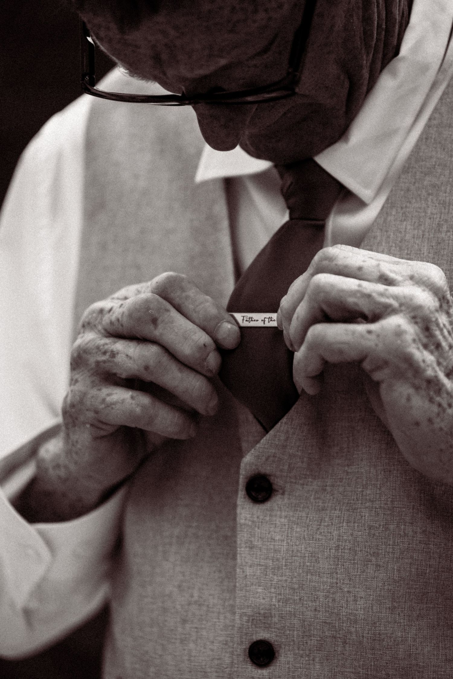 Close-up sequence showing hands buttoning a formal dress shirt in black and white.