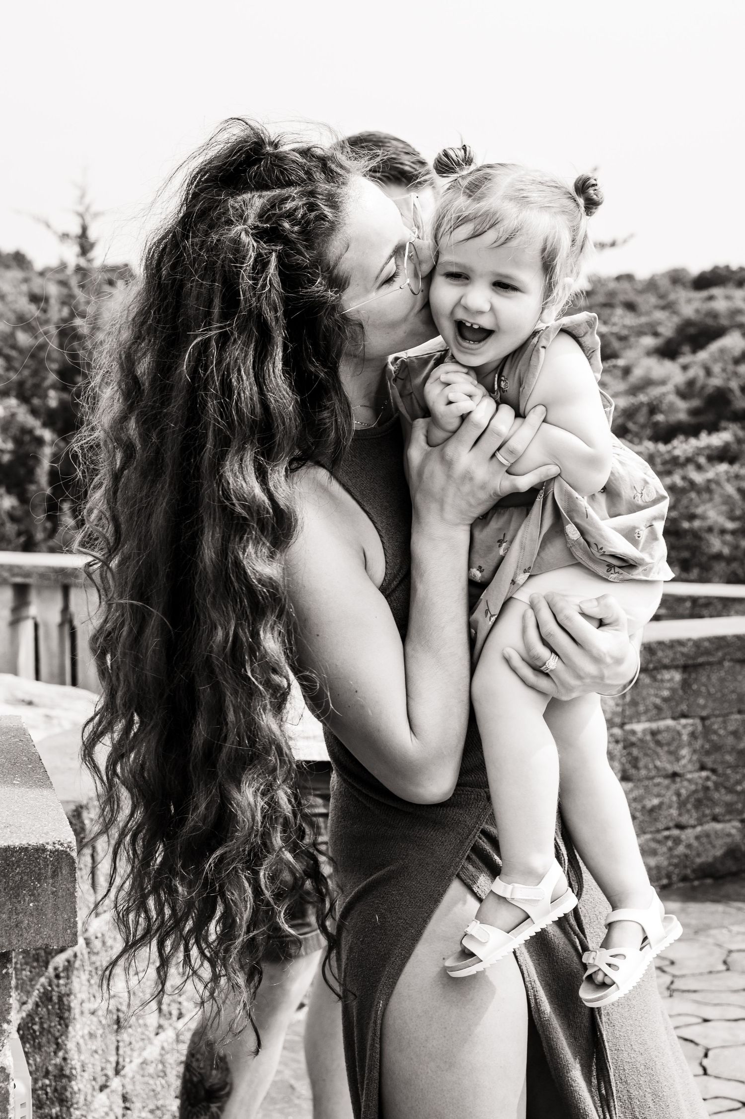 Black and white portrait series showing intimate moments of parental affection with a baby.