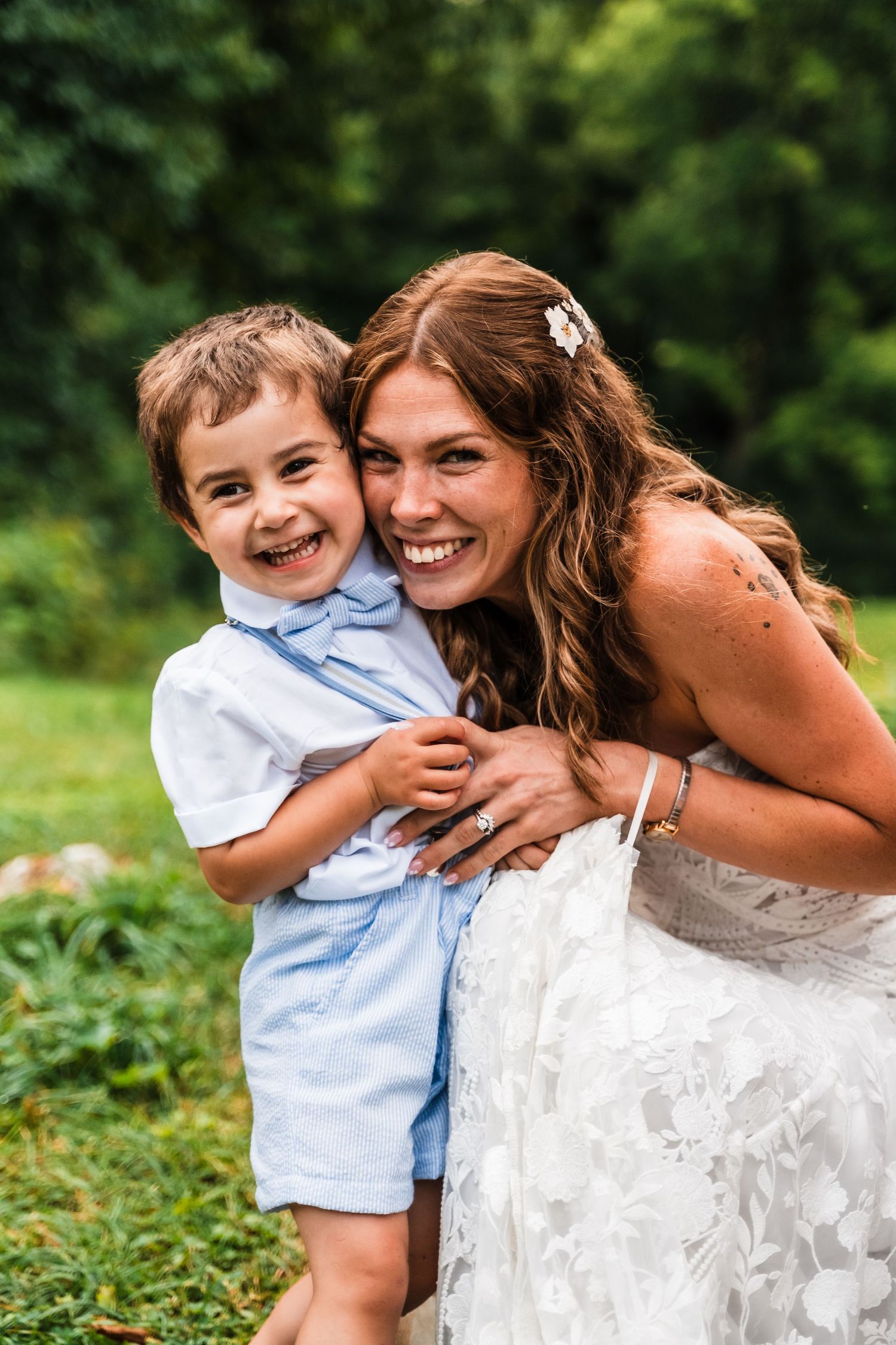 A joyful moment shared in a garden setting wearing light blue and white formal attire.