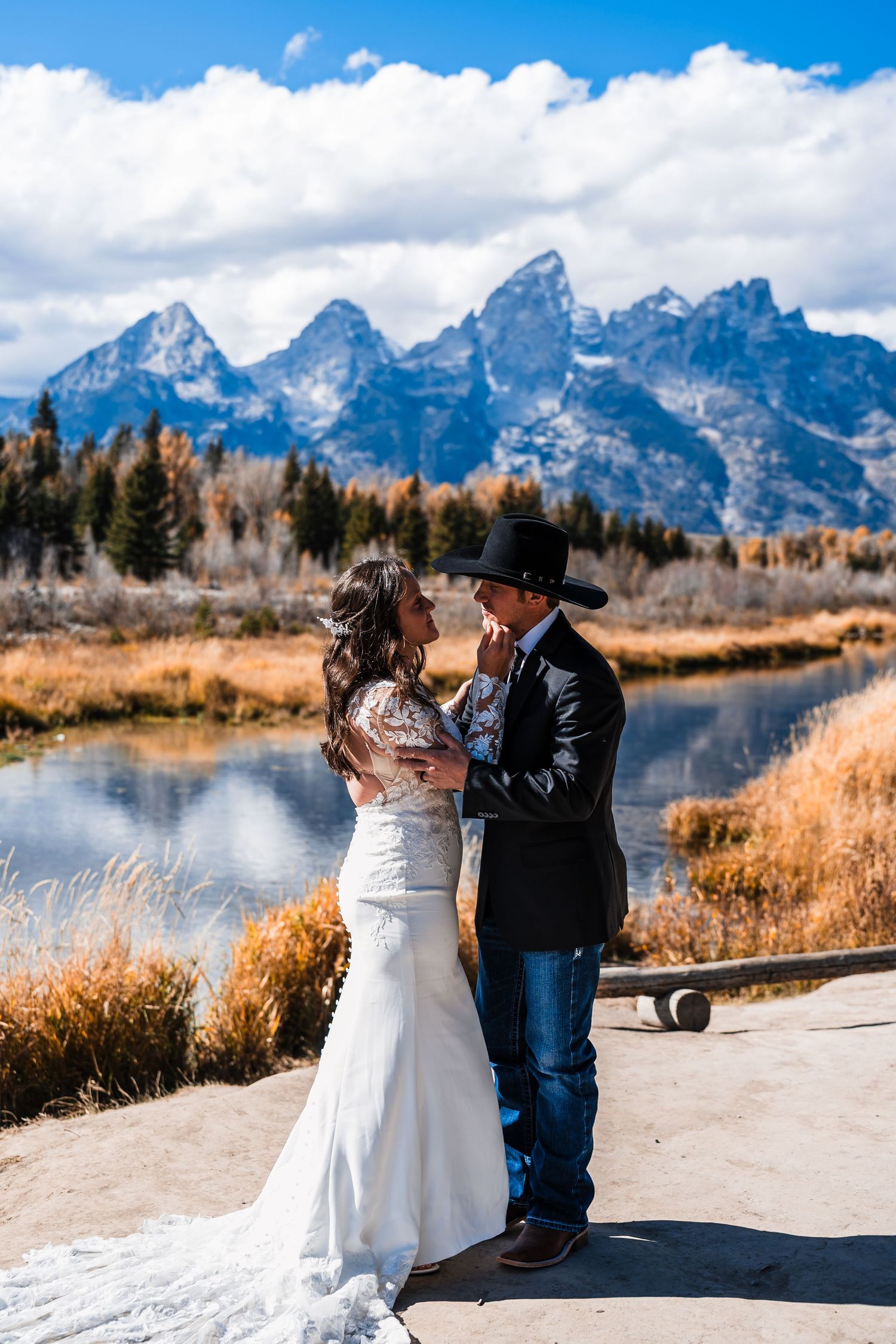 Wedding couple shares an intimate moment by a lake with the majestic Teton mountains as their backdrop.