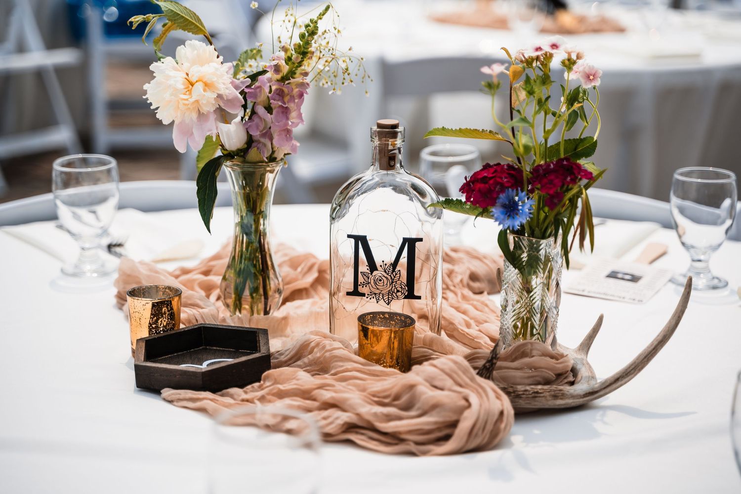 Elegant wedding reception table settings with floral centerpieces and blush-colored runners.