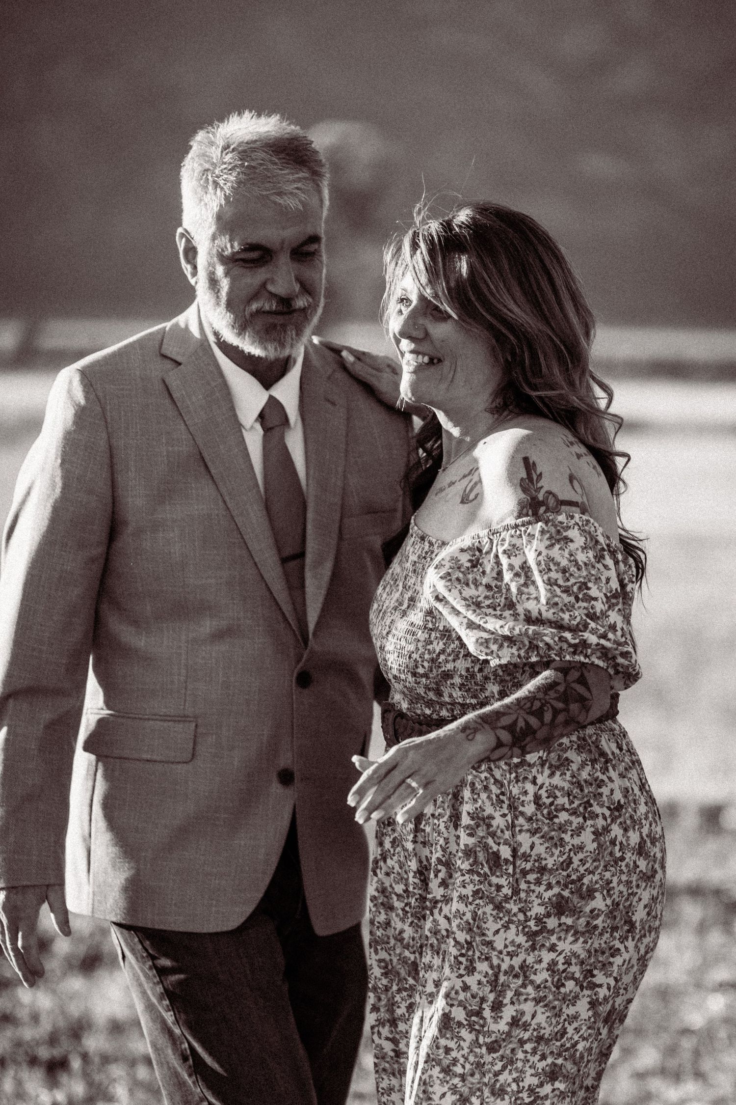 A romantic black and white photo series showing a couple dancing together in a field.