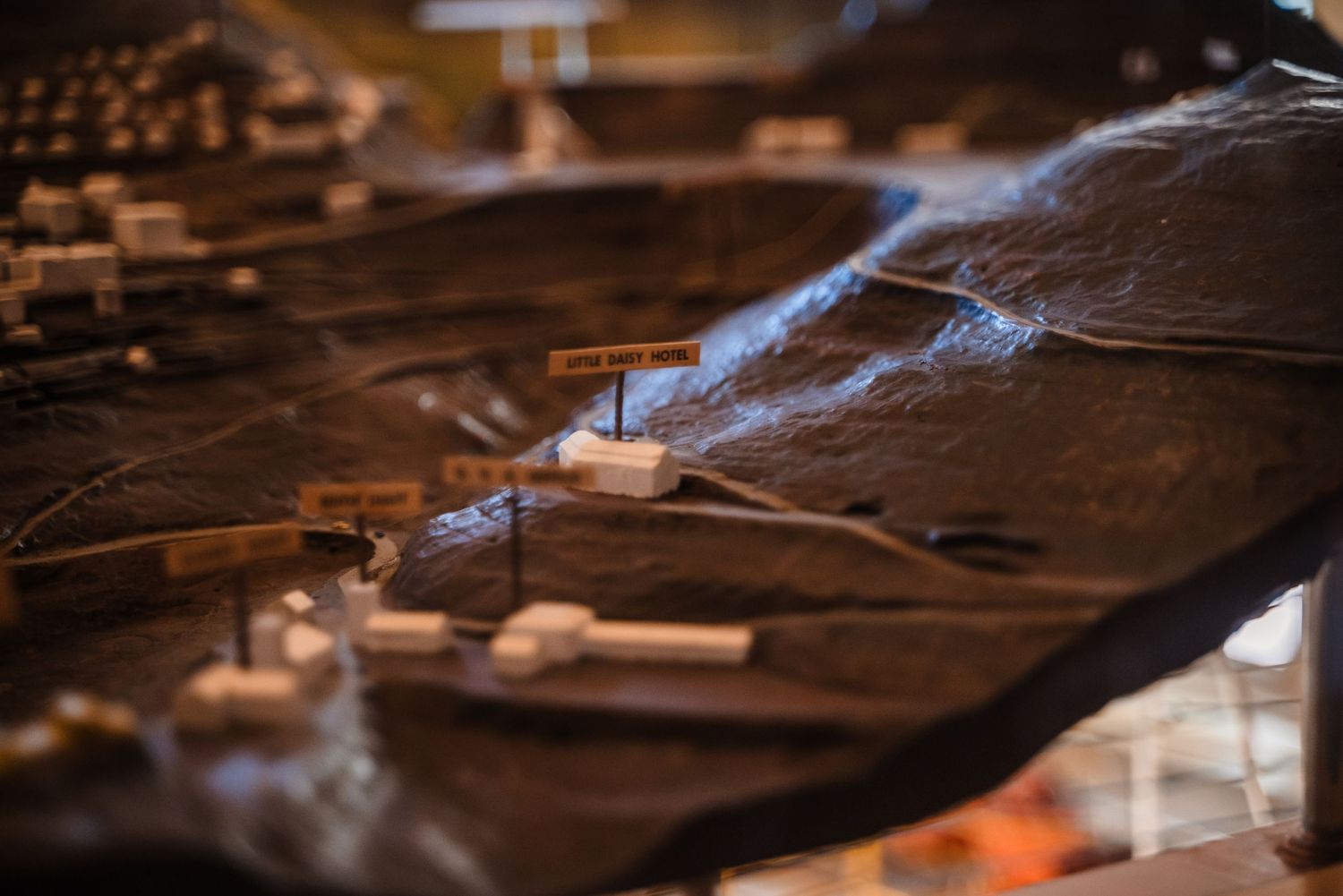 Close-up of sawdust and smoke rising from woodworking machinery in dark atmospheric lighting.